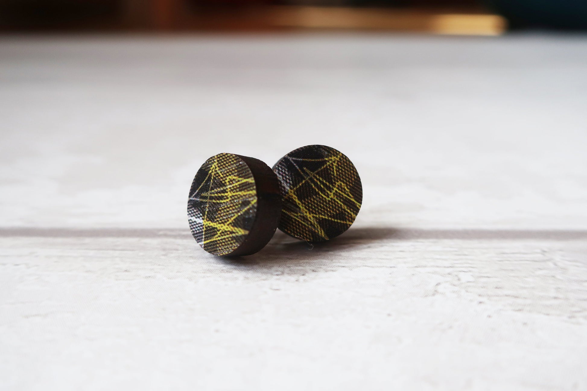 Pair of round earrings with geometric pattern on a white surface