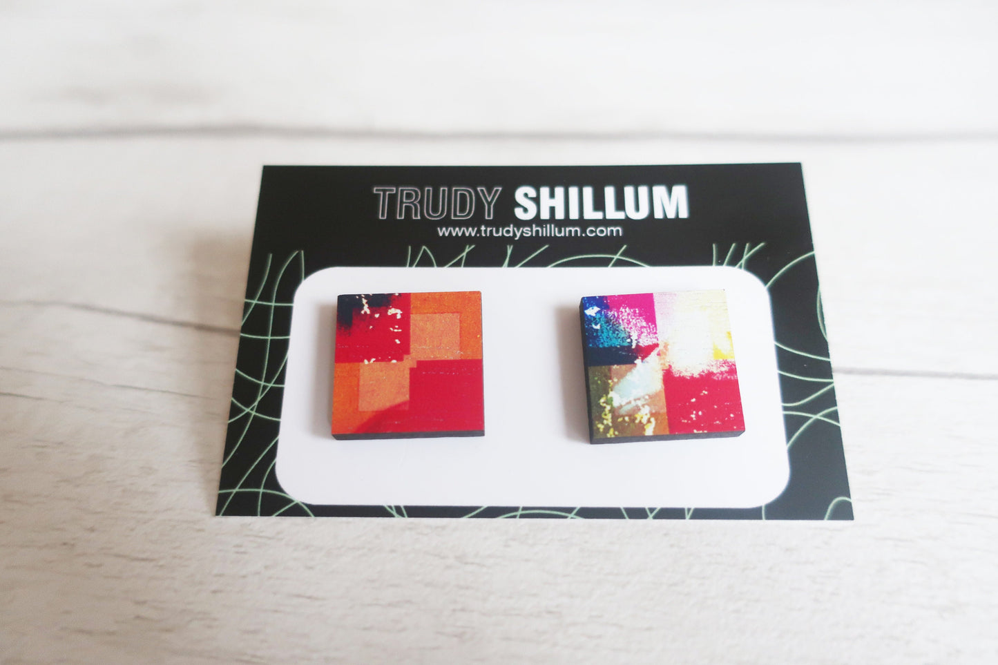 Colorful square earrings on a Trudy Shillum branded card.