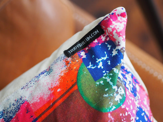 Colorful pillow with a brand label on a blurred background
