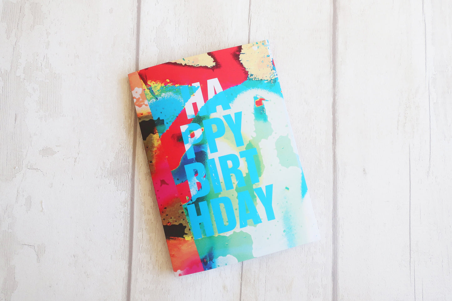 Colorful birthday card on a white wooden surface