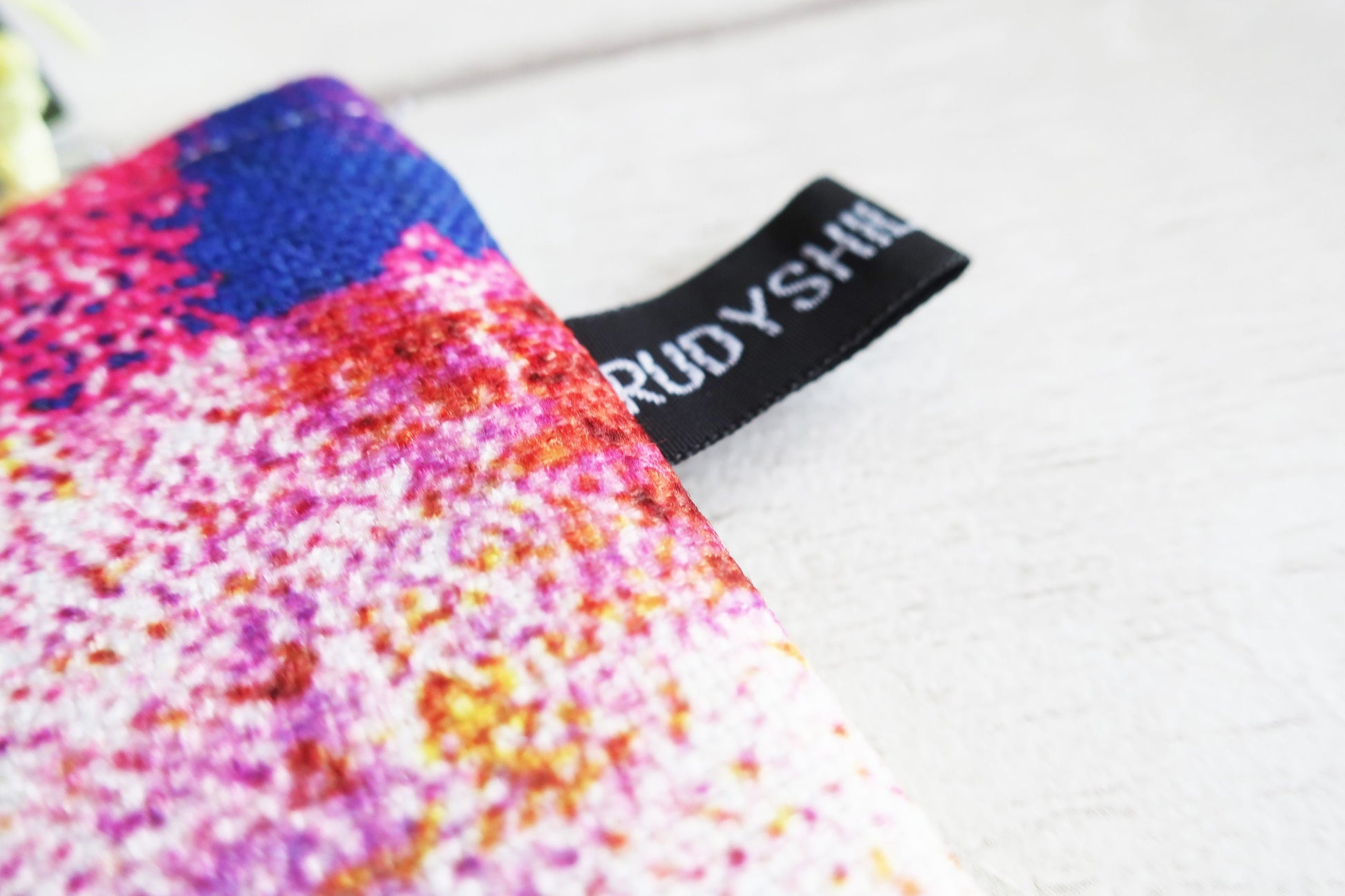 Colorful textured pouch with a black tag displaying 'TRUDY SHILLUM' on a white background