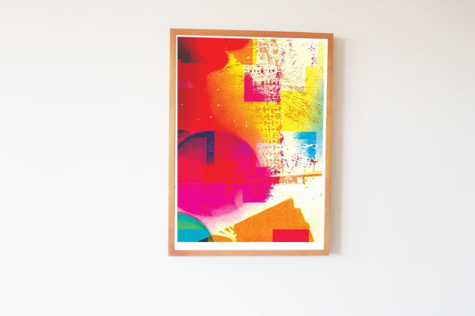Colorful abstract art print in a wooden frame on a white wall