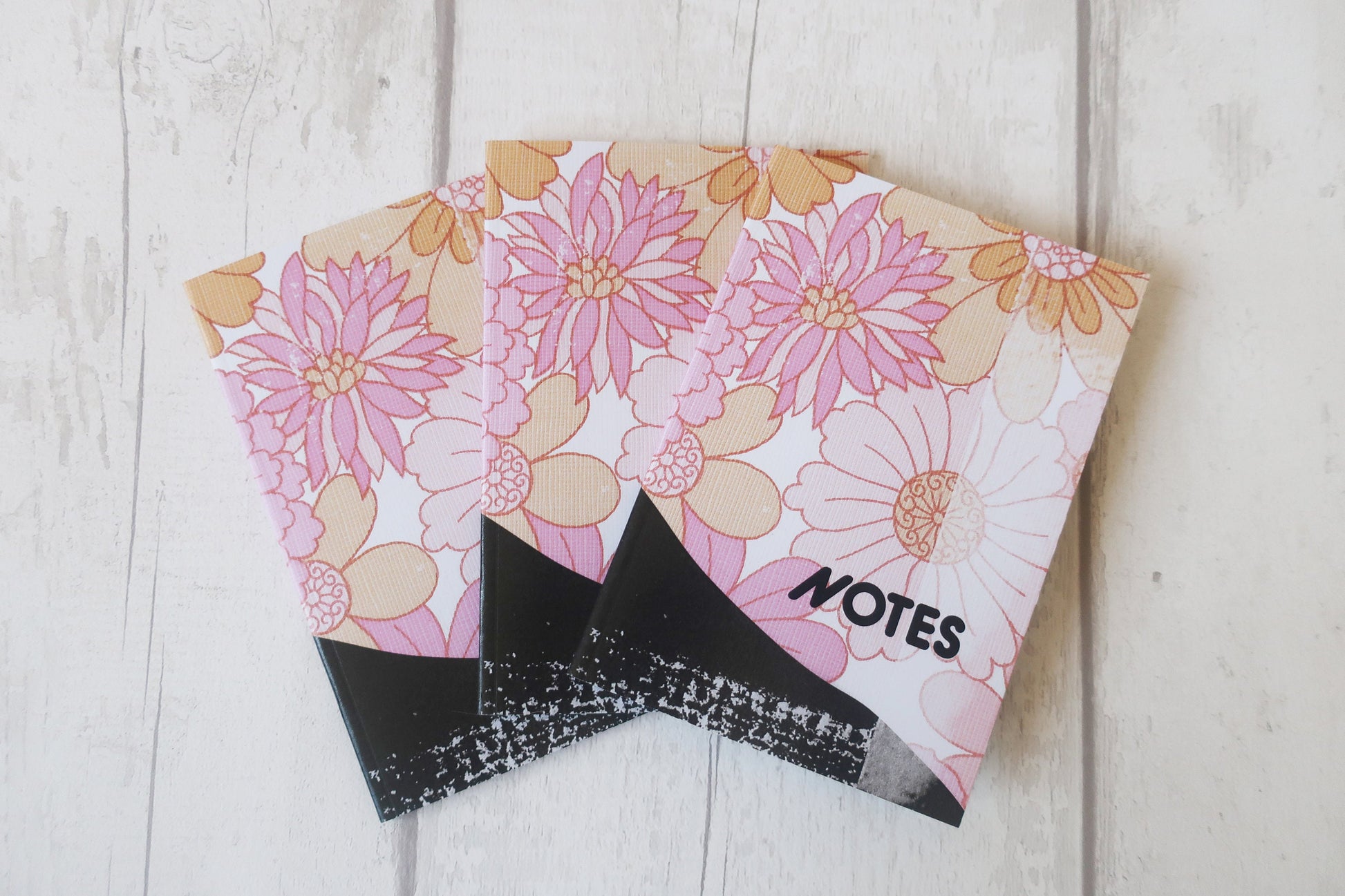 Floral notebook with 'NOTES' label on a wooden surface