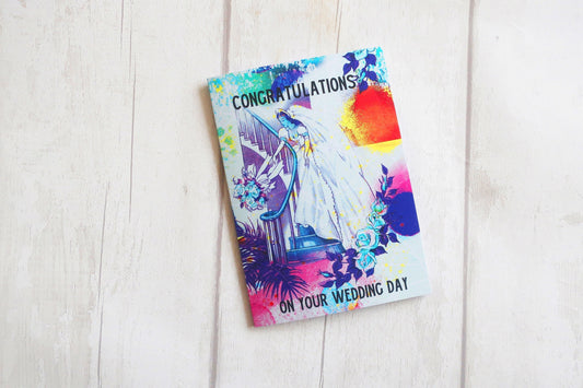 Colorful wedding card with 'Congratulations on your wedding day' text on a light wooden surface.