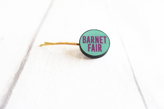 Green hair clip with 'Barnet Fair' text on a white background