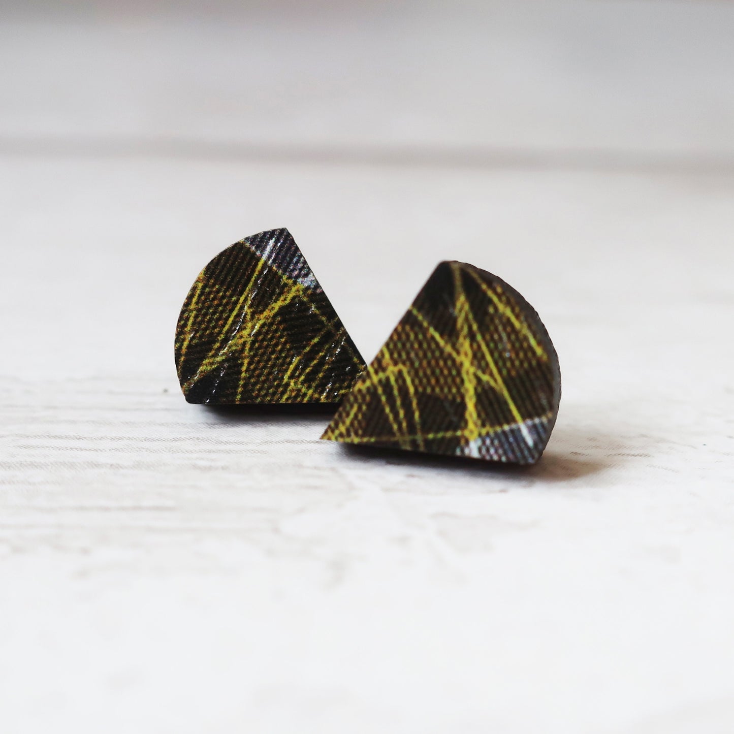 Pair of black and yellow patterned earrings on a white background