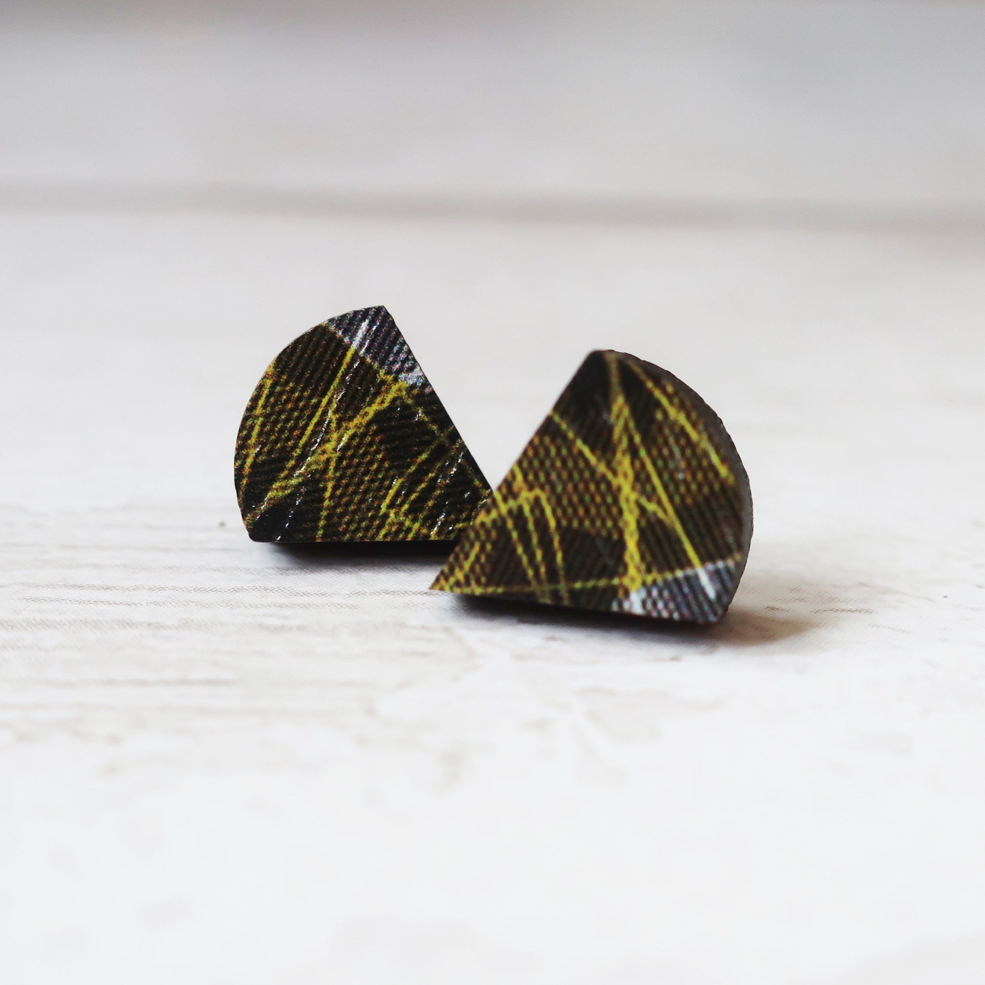 Pair of black and yellow patterned earrings on a white background