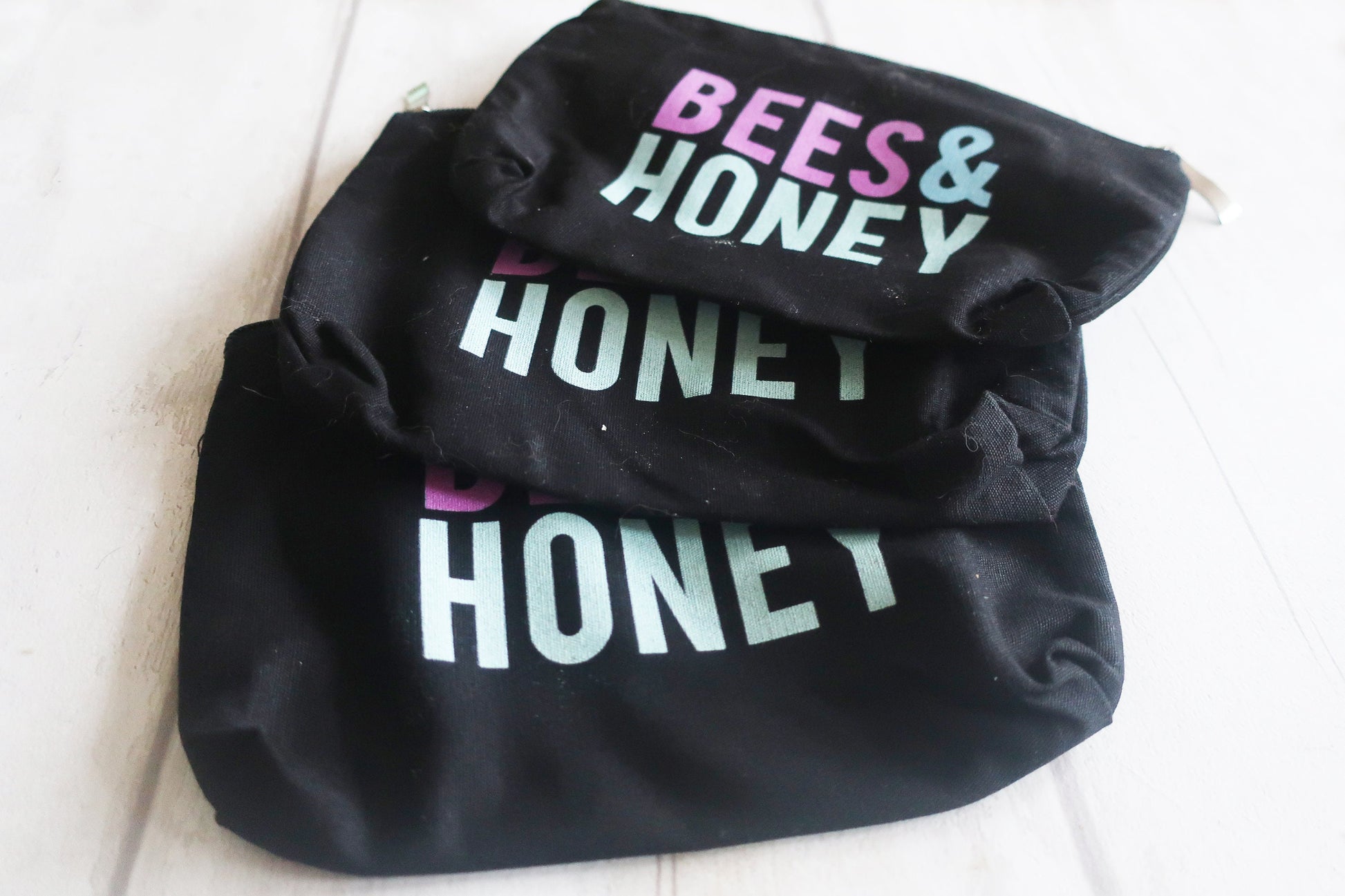 Black bag with 'BEES & HONEY' text on a white background