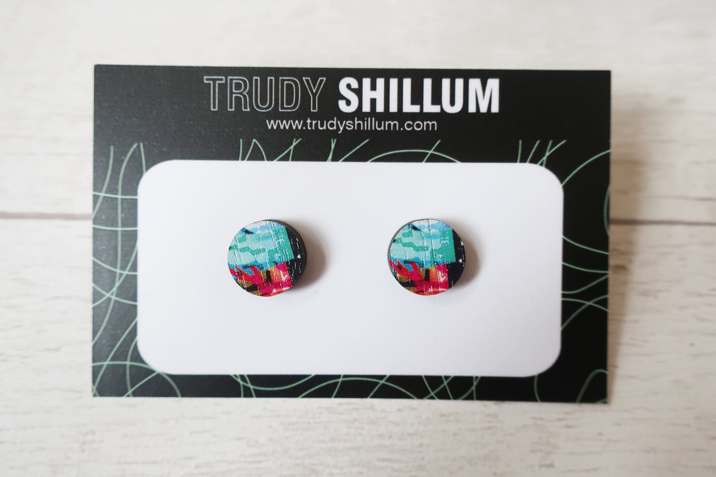 Pair of colorful earrings on a Trudy Shillum branded card.