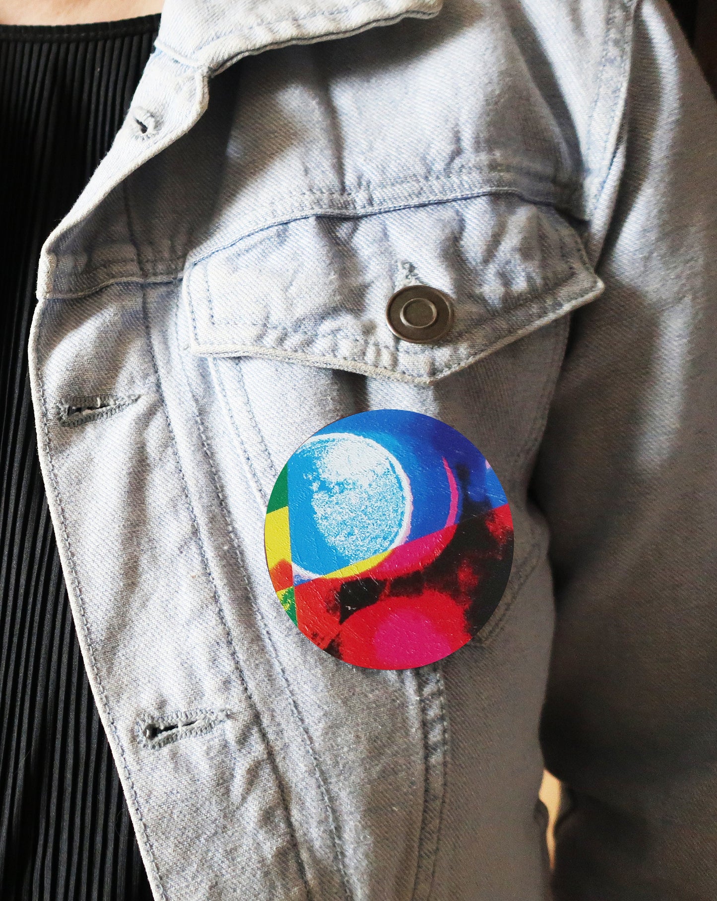Colorful circular design brooch on a denim jacket
