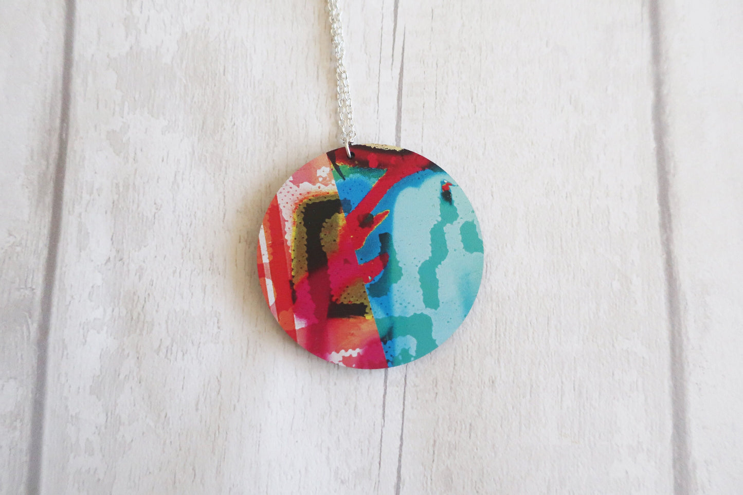 Colorful circular pendant on a white wooden surface