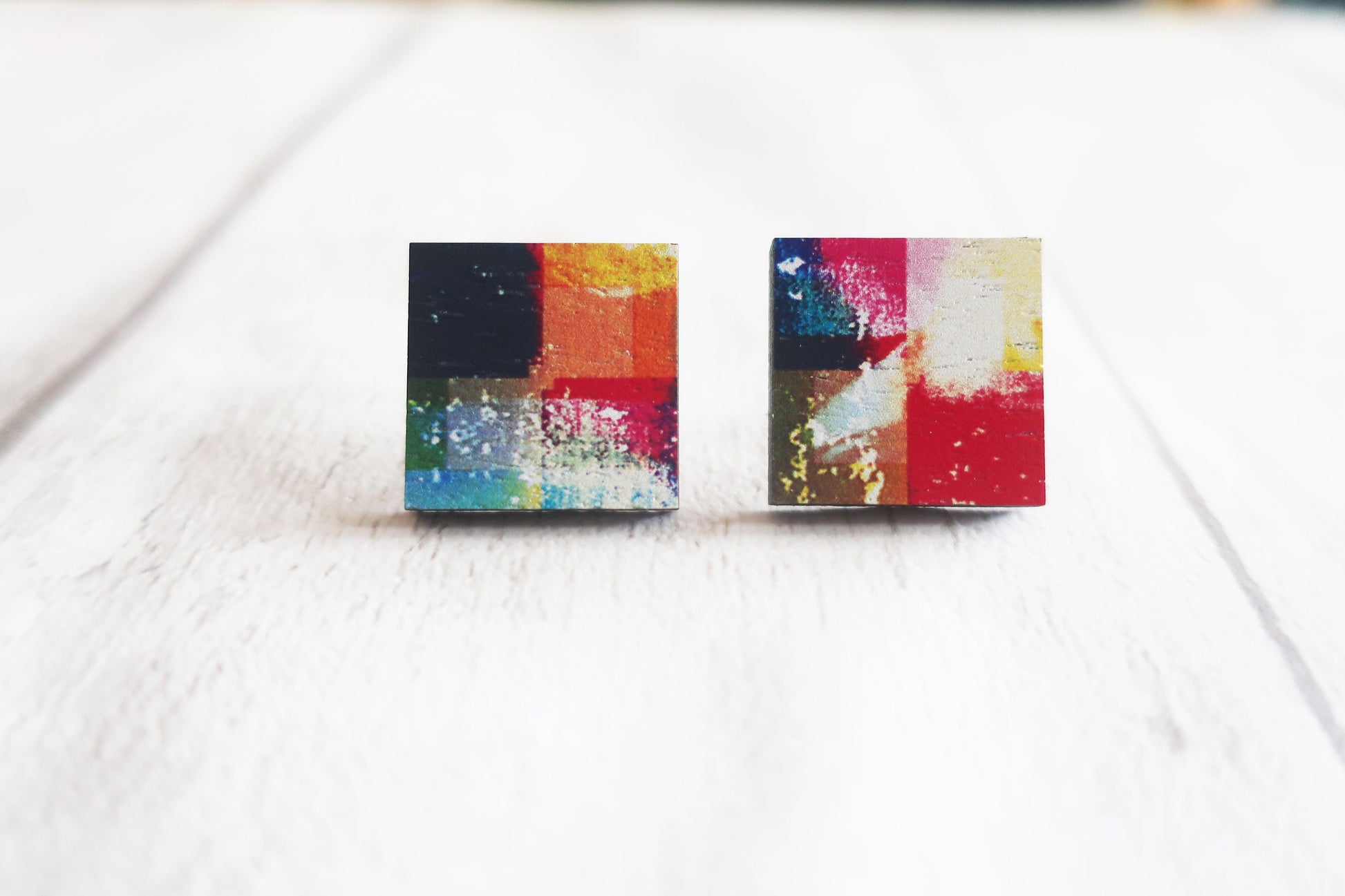 Pair of colorful square earrings on a light background