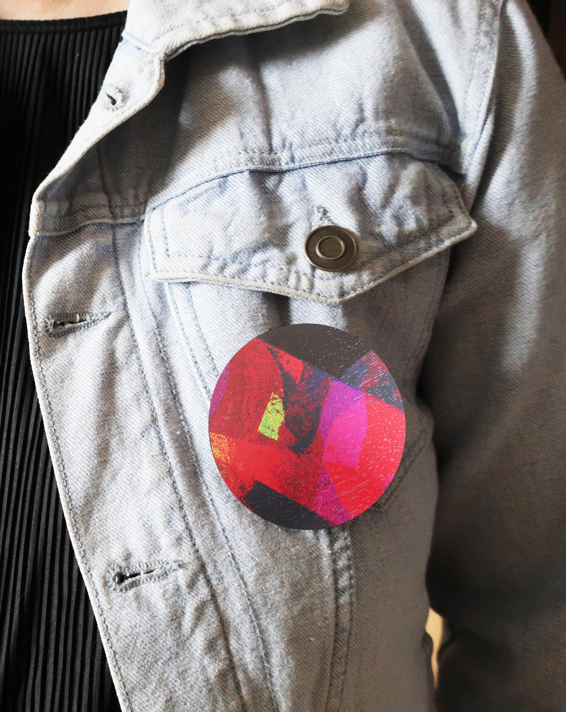 Colorful circular brooch on a denim jacket
