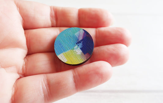 Color pin badge on a hand with a white background