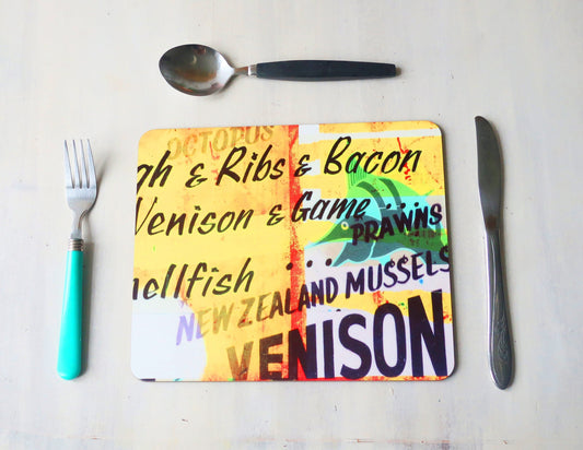 Colorful placemat with text on a white surface with utensils