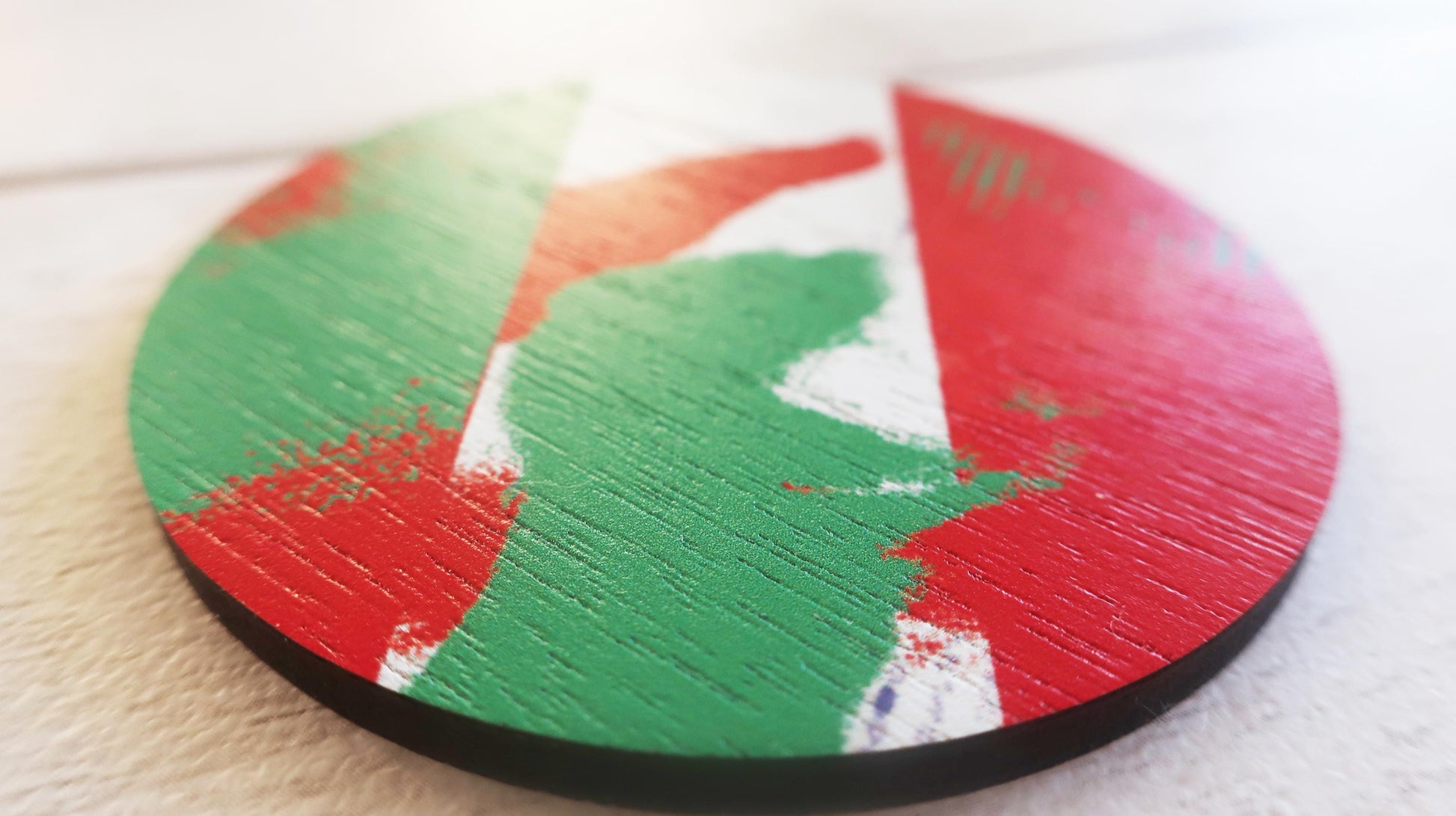 Round brooch with a colorful design on a white surface