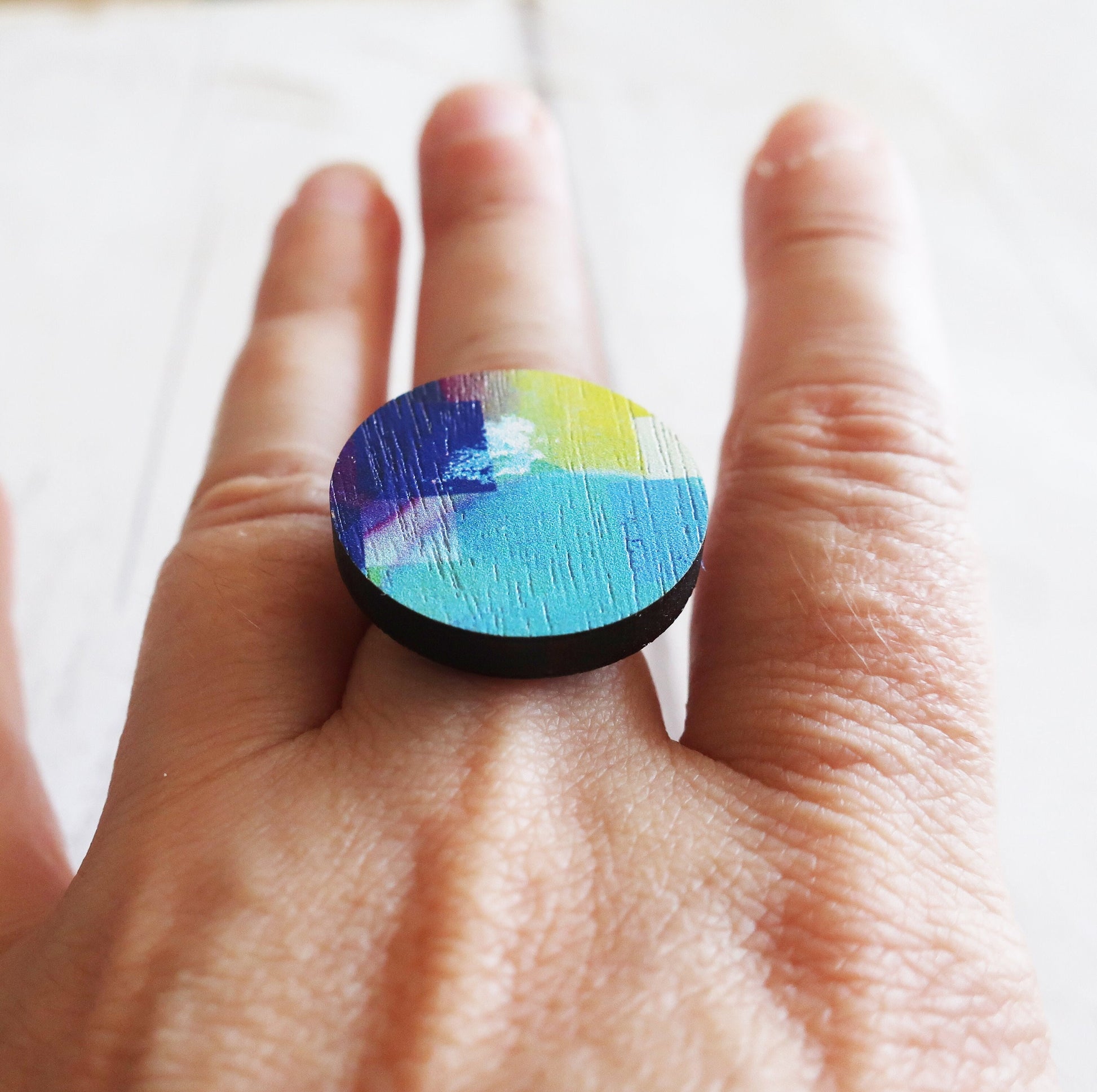 Colorful ring on a person's finger with a blurred background