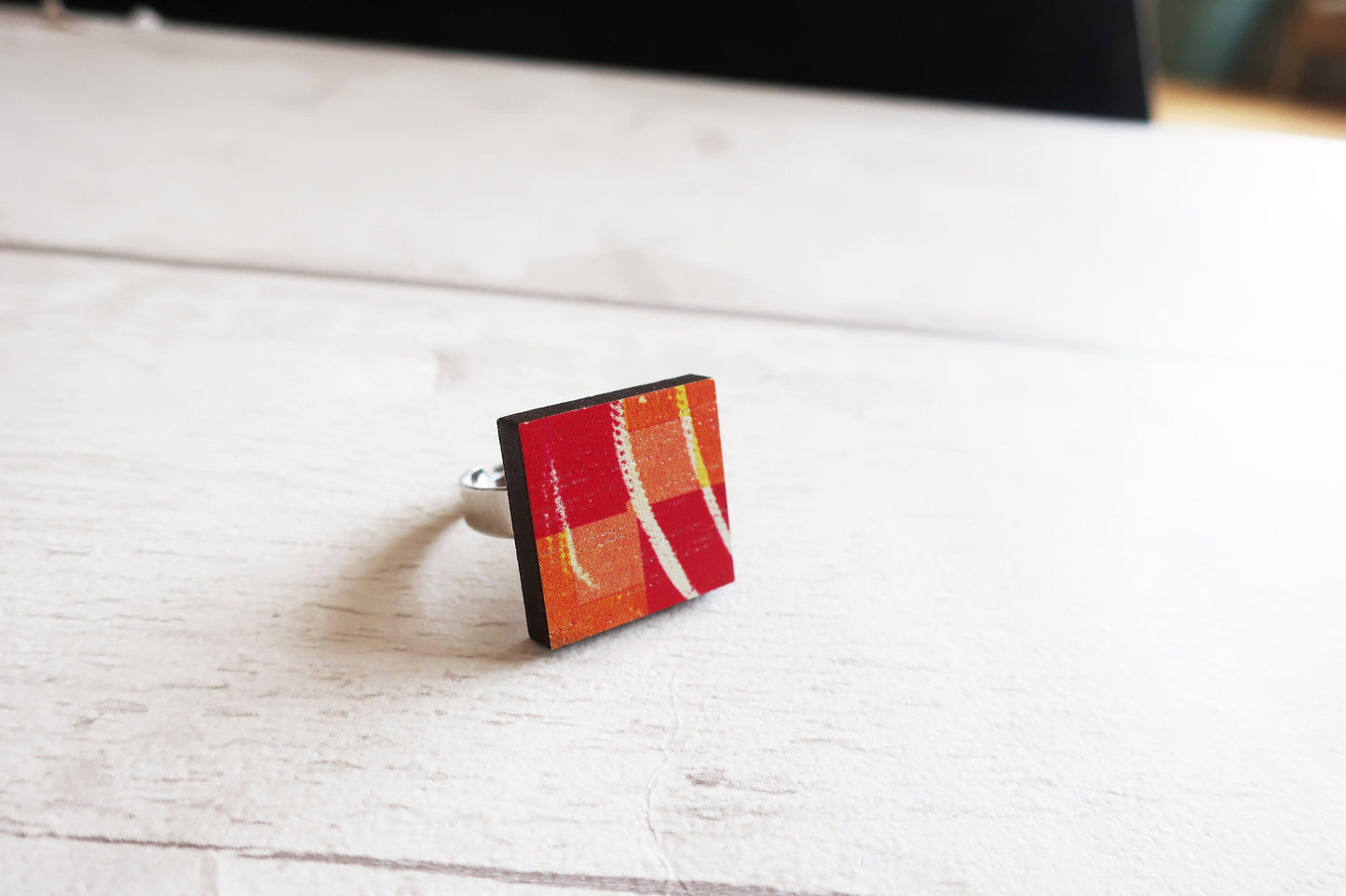 Ring with a colorful pattern on a light wooden surface