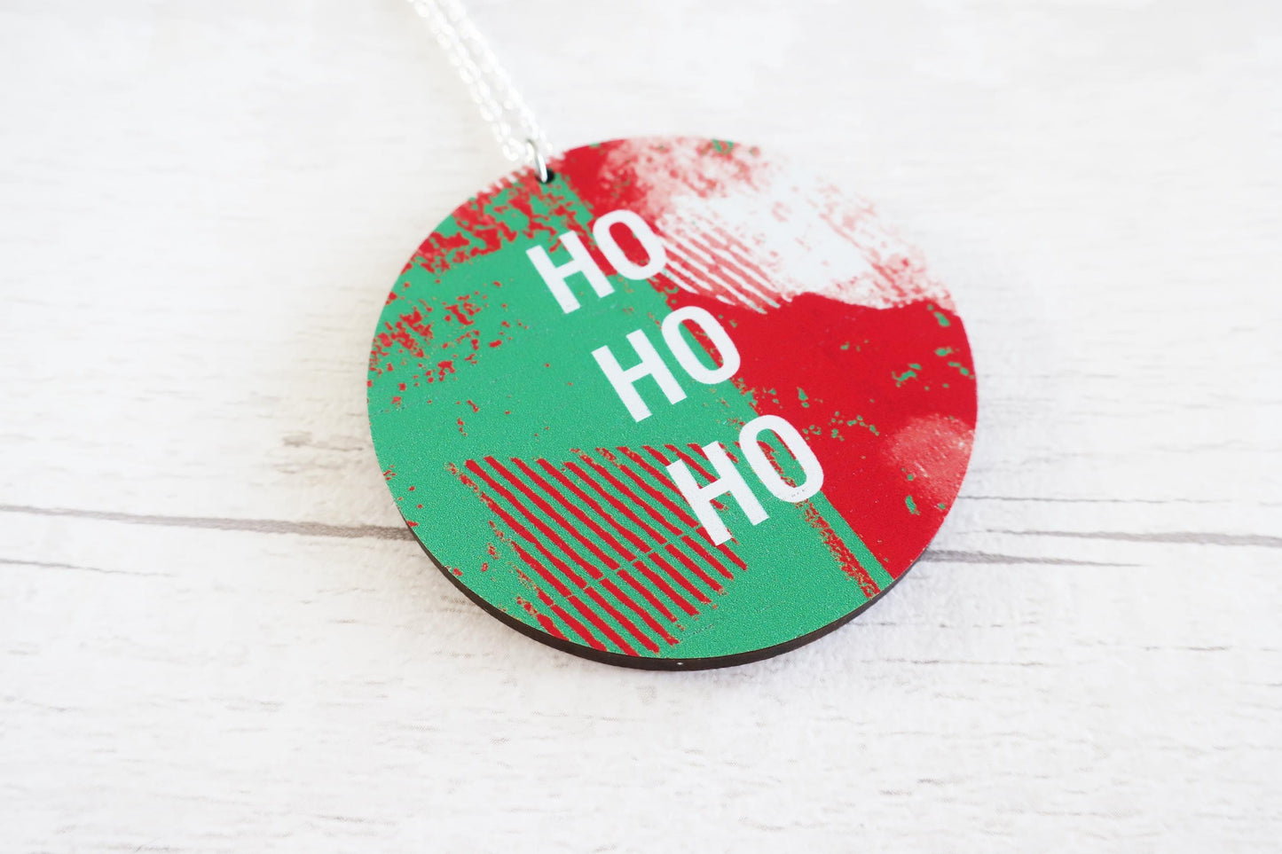 Round Christmas necklace with 'HO HO HO' text on a white background