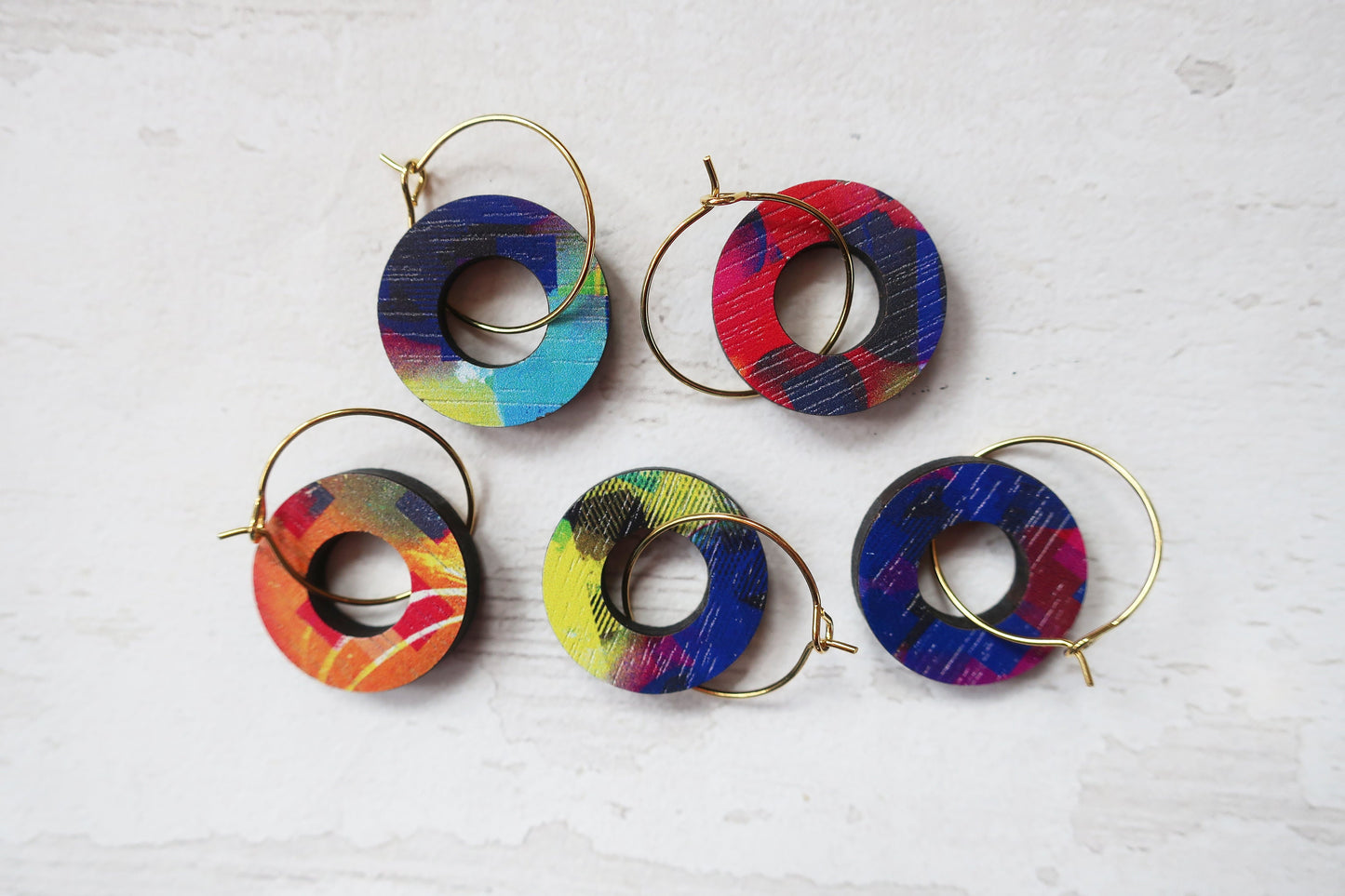 Set of colorful hoop earrings on a light gray background