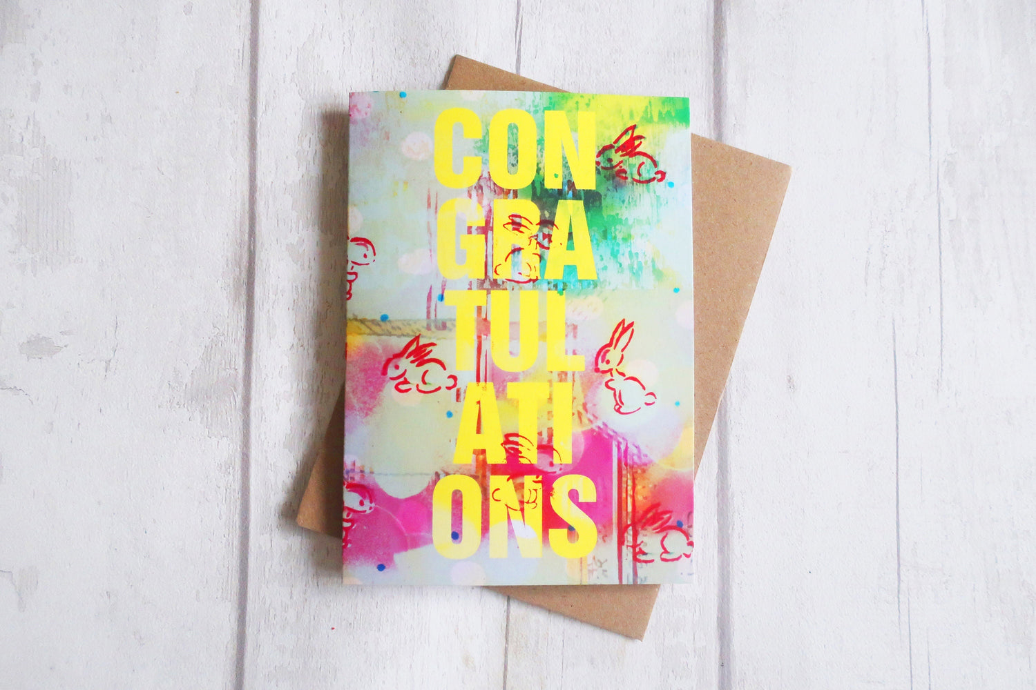 Colorful greeting card with text and graphics on a wooden surface