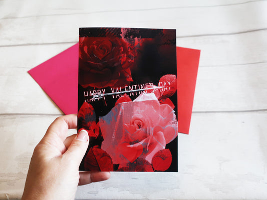 Hand holding red rose valentines card