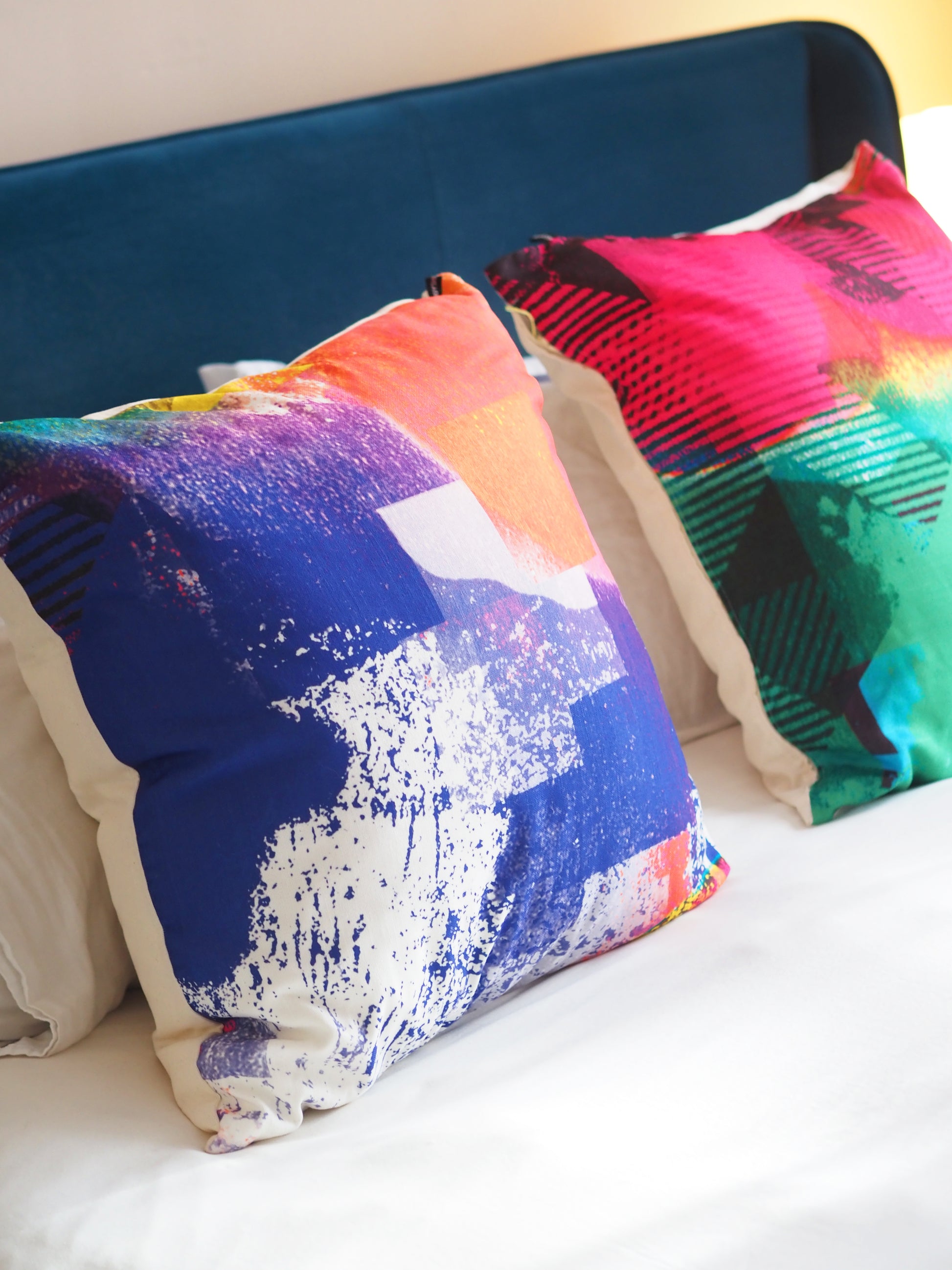 Colorful abstract-patterned pillows on a bed