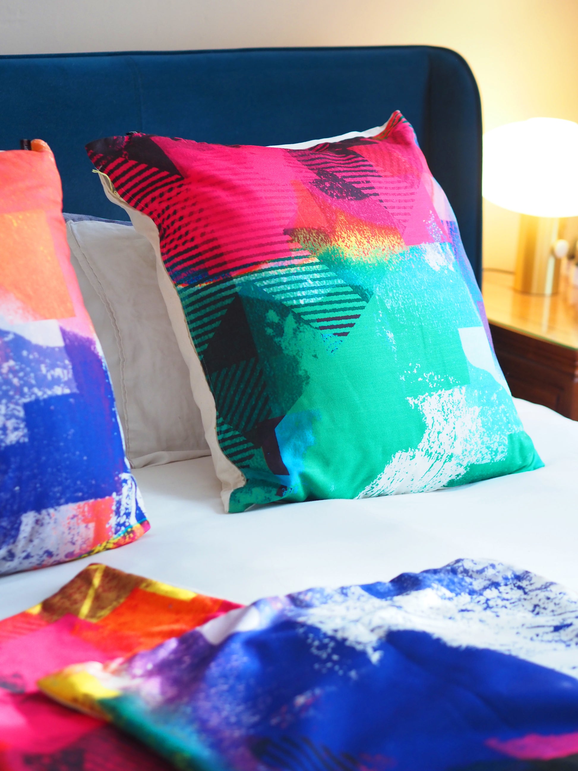 Colorful abstract-patterned pillows on a bed