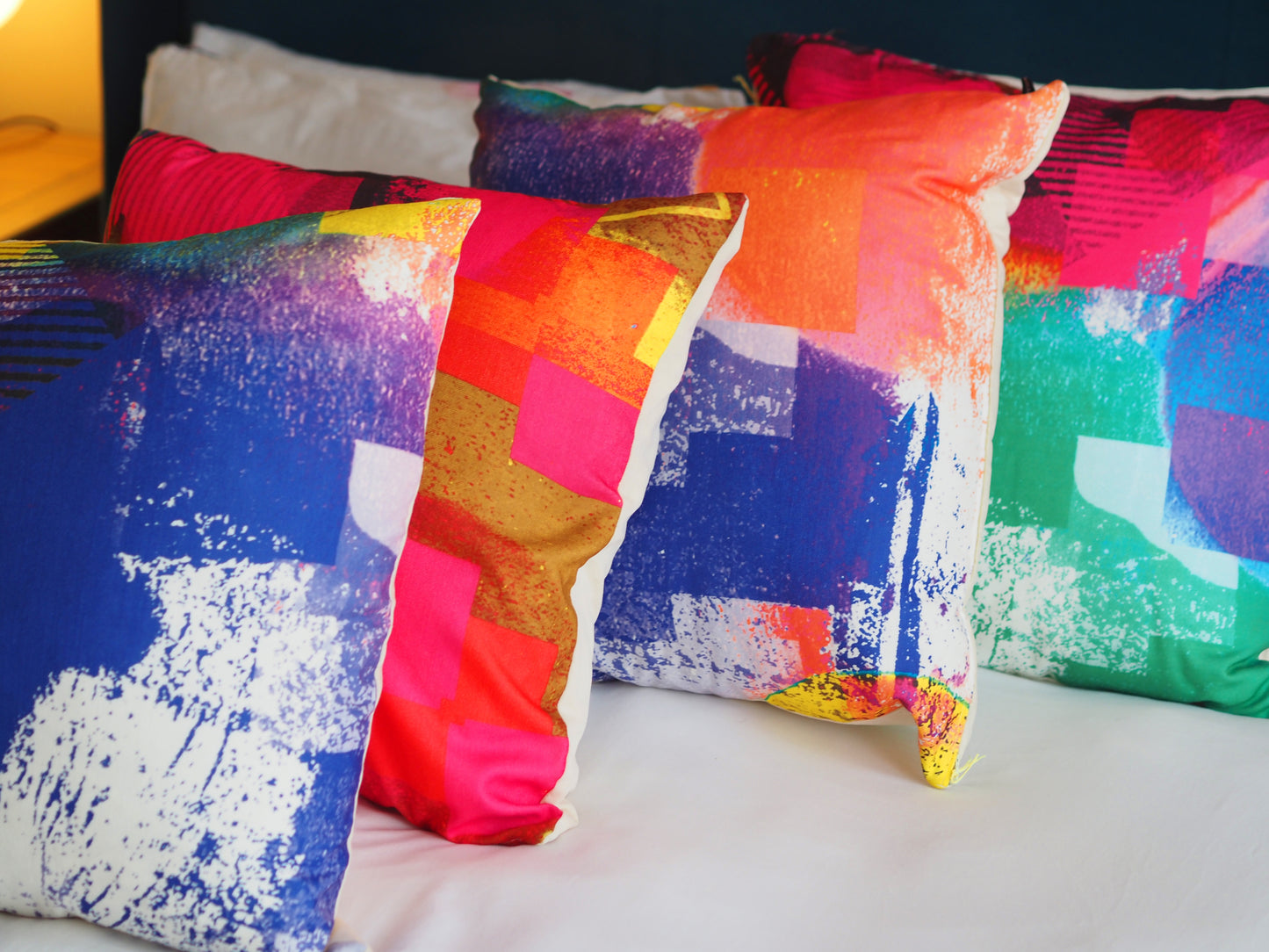 Colorful abstract-patterned pillows on a bed