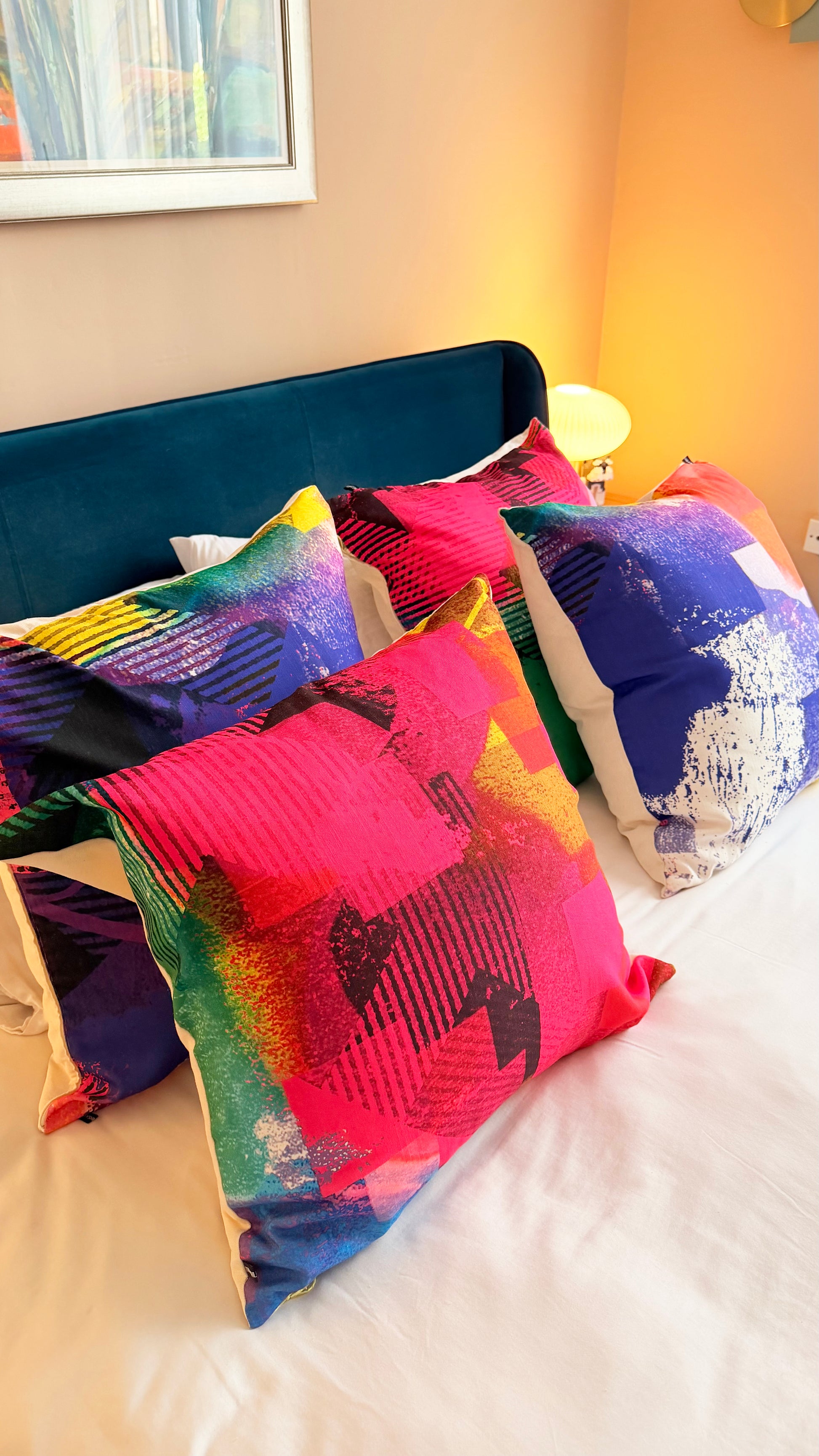 Colorful pillows on a bed with a blue headboard