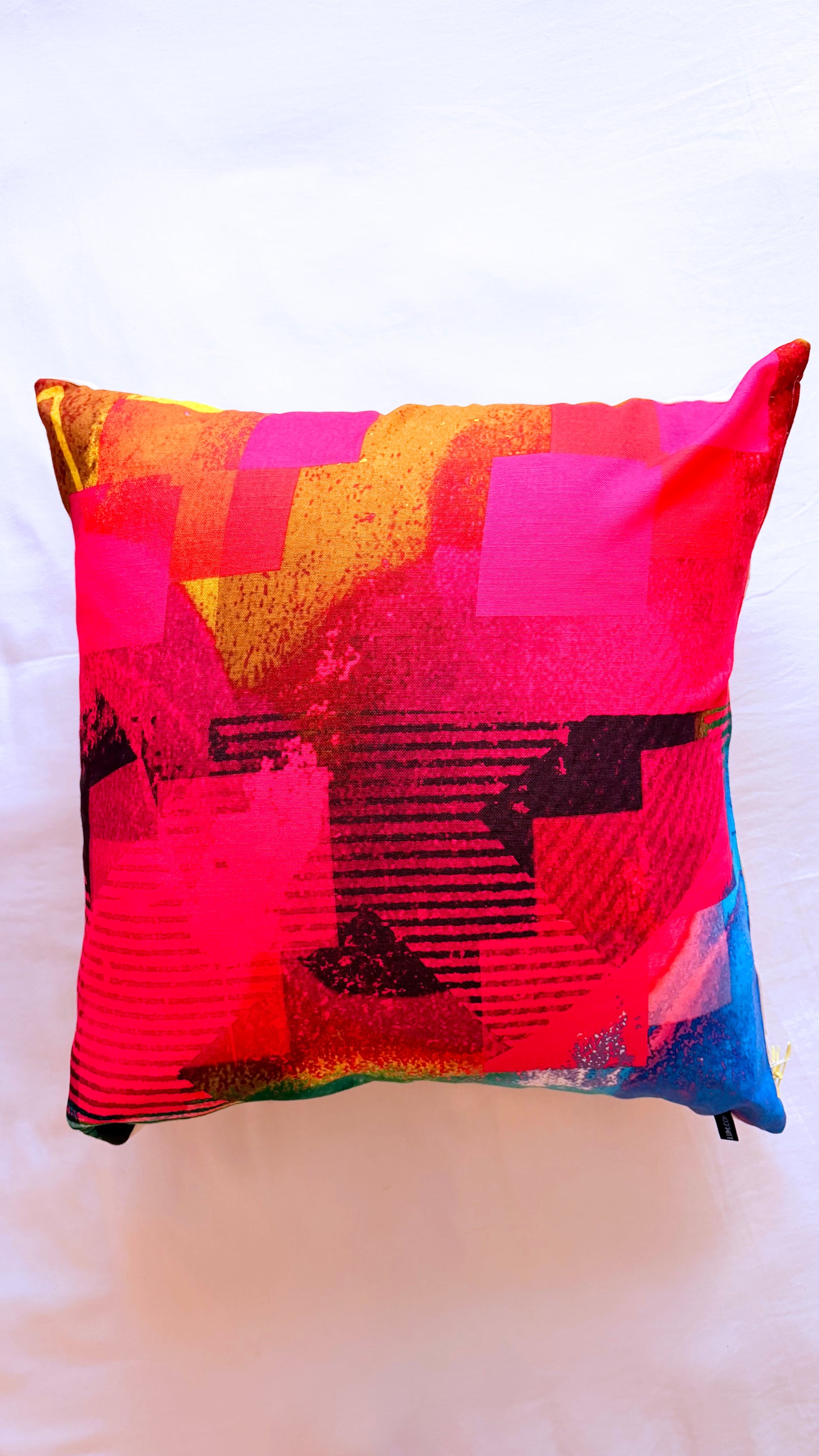 Colorful geometric-patterned pillow on a white background