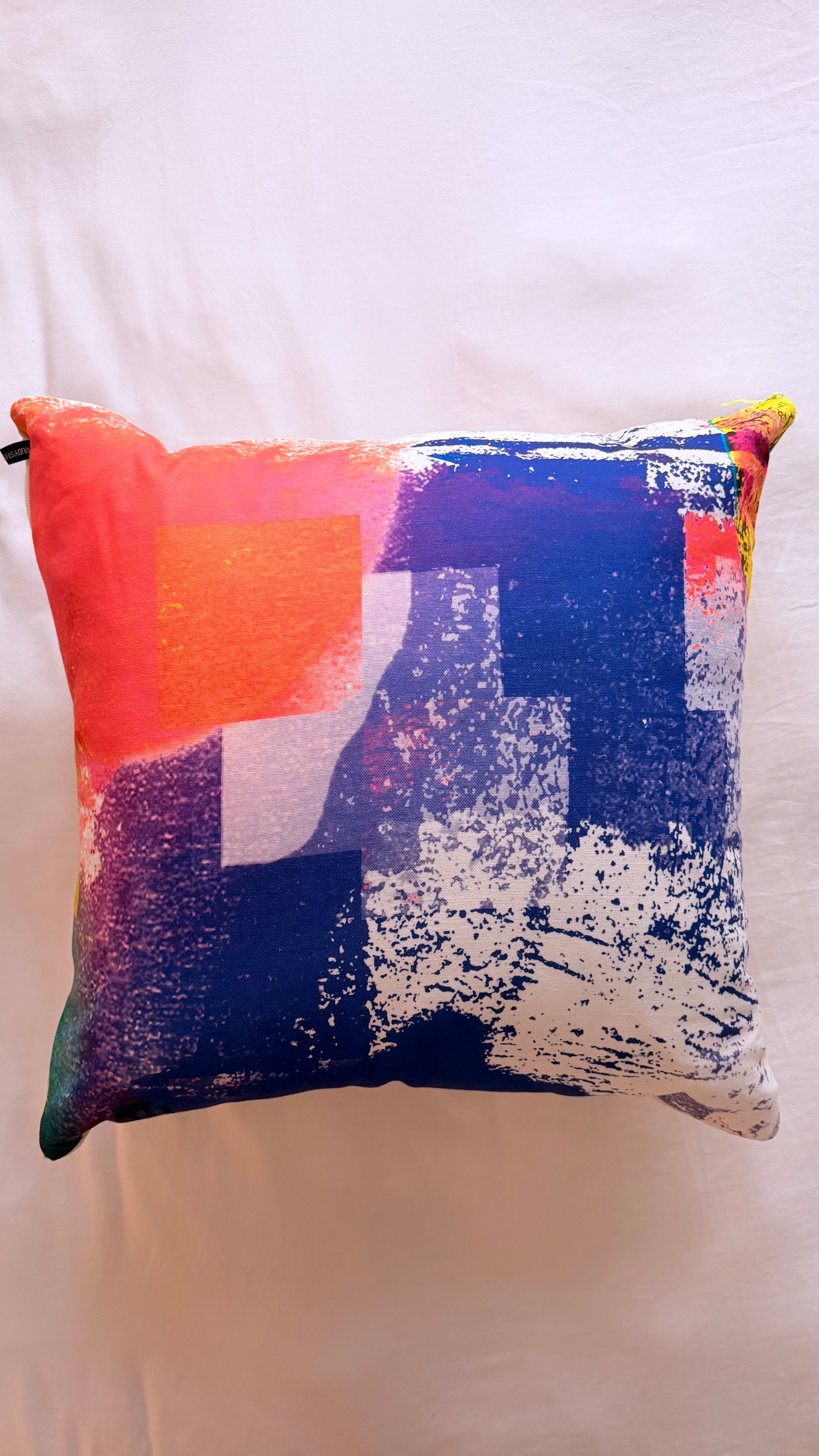 Colorful abstract-patterned pillow on a white background