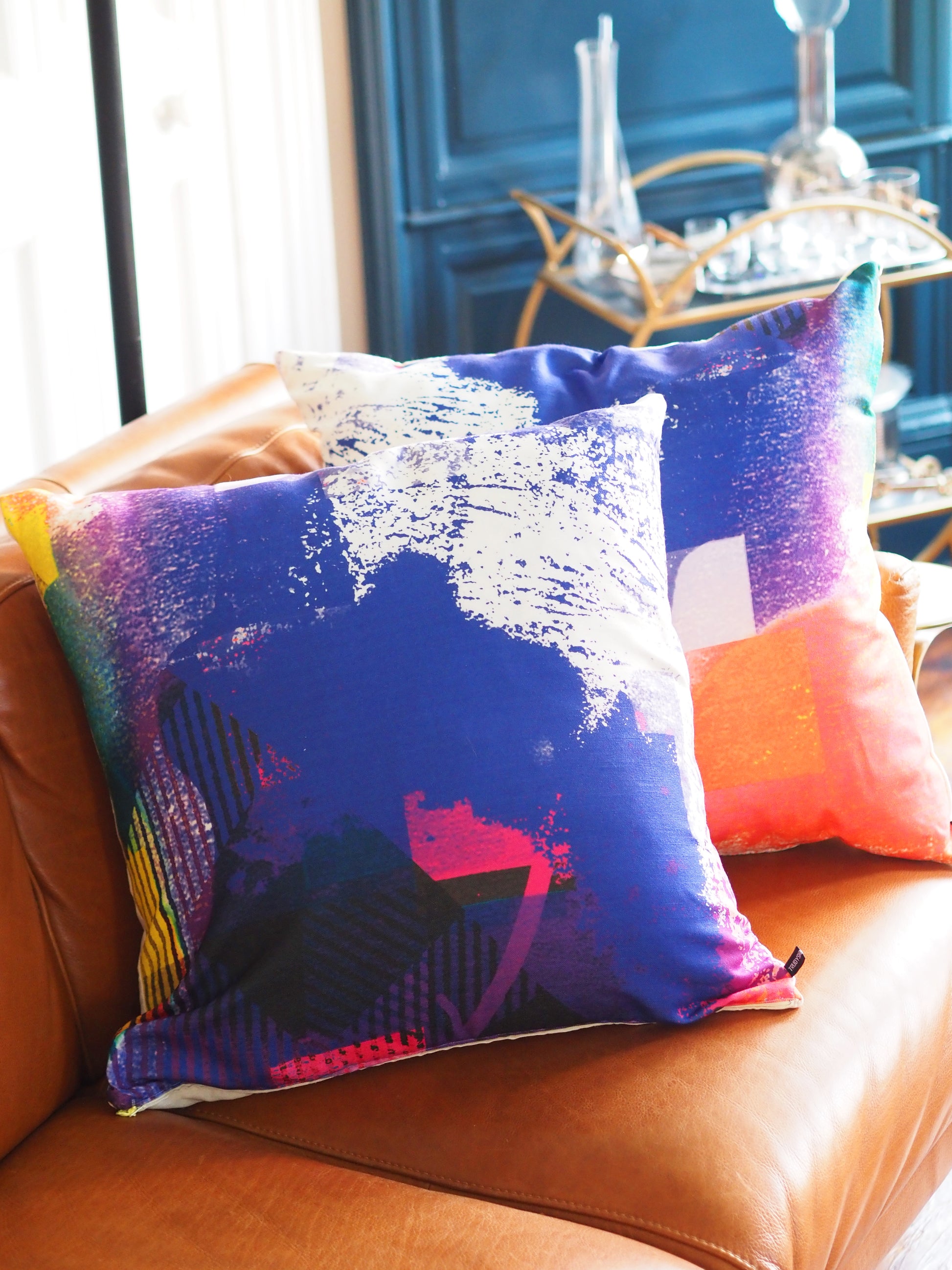 Colorful pillow with abstract design on a brown couch