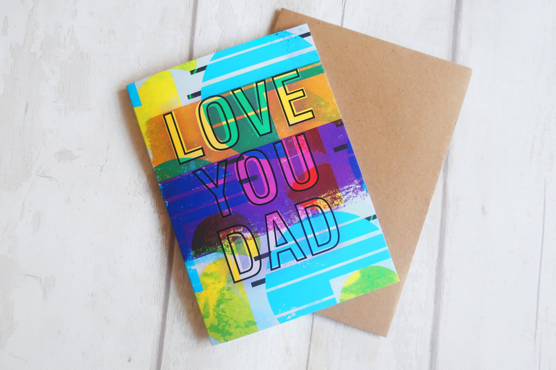 Colorful card with 'Love You Dad' text on a wooden surface