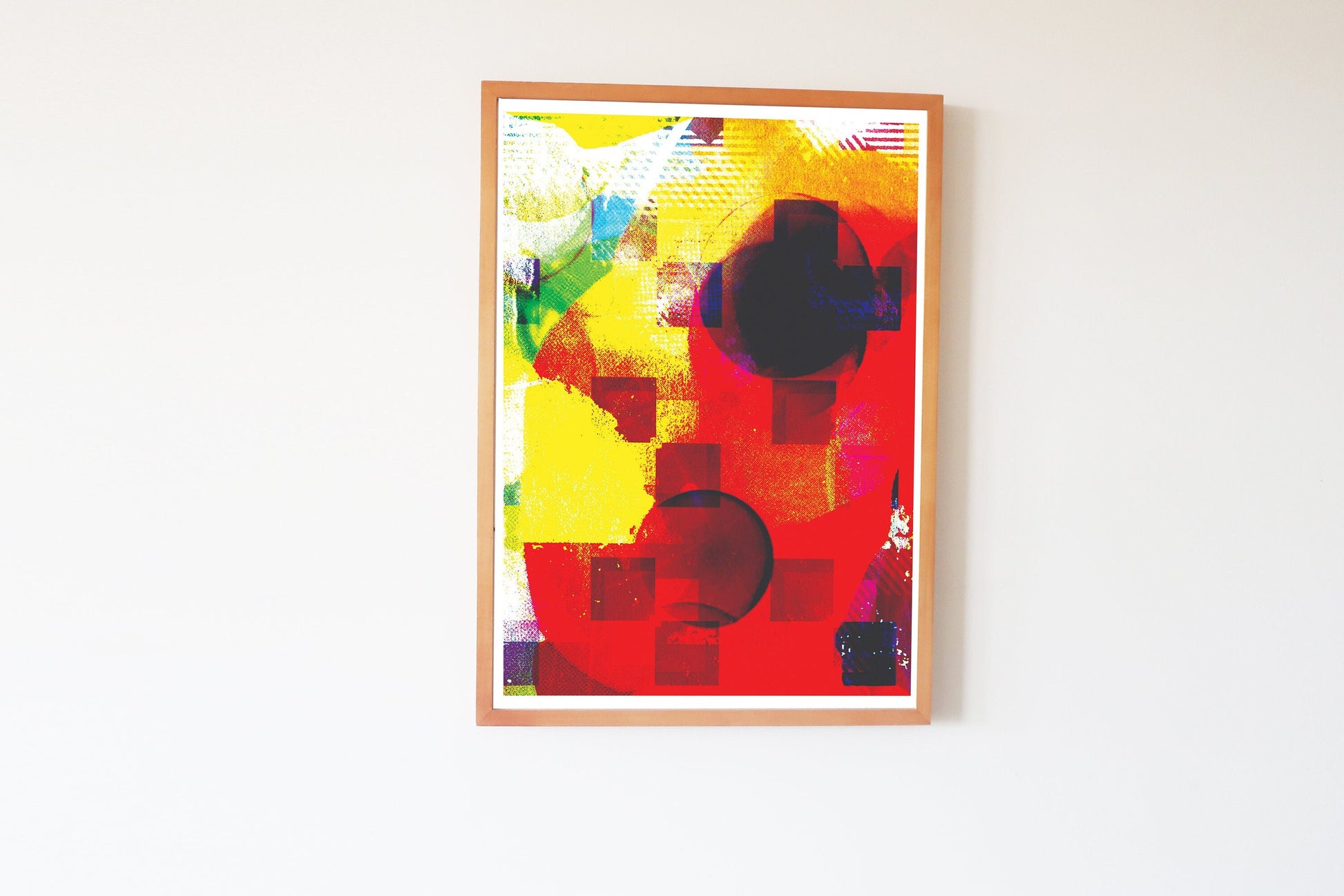 Framed abstract artwork with vibrant colors on a white wall