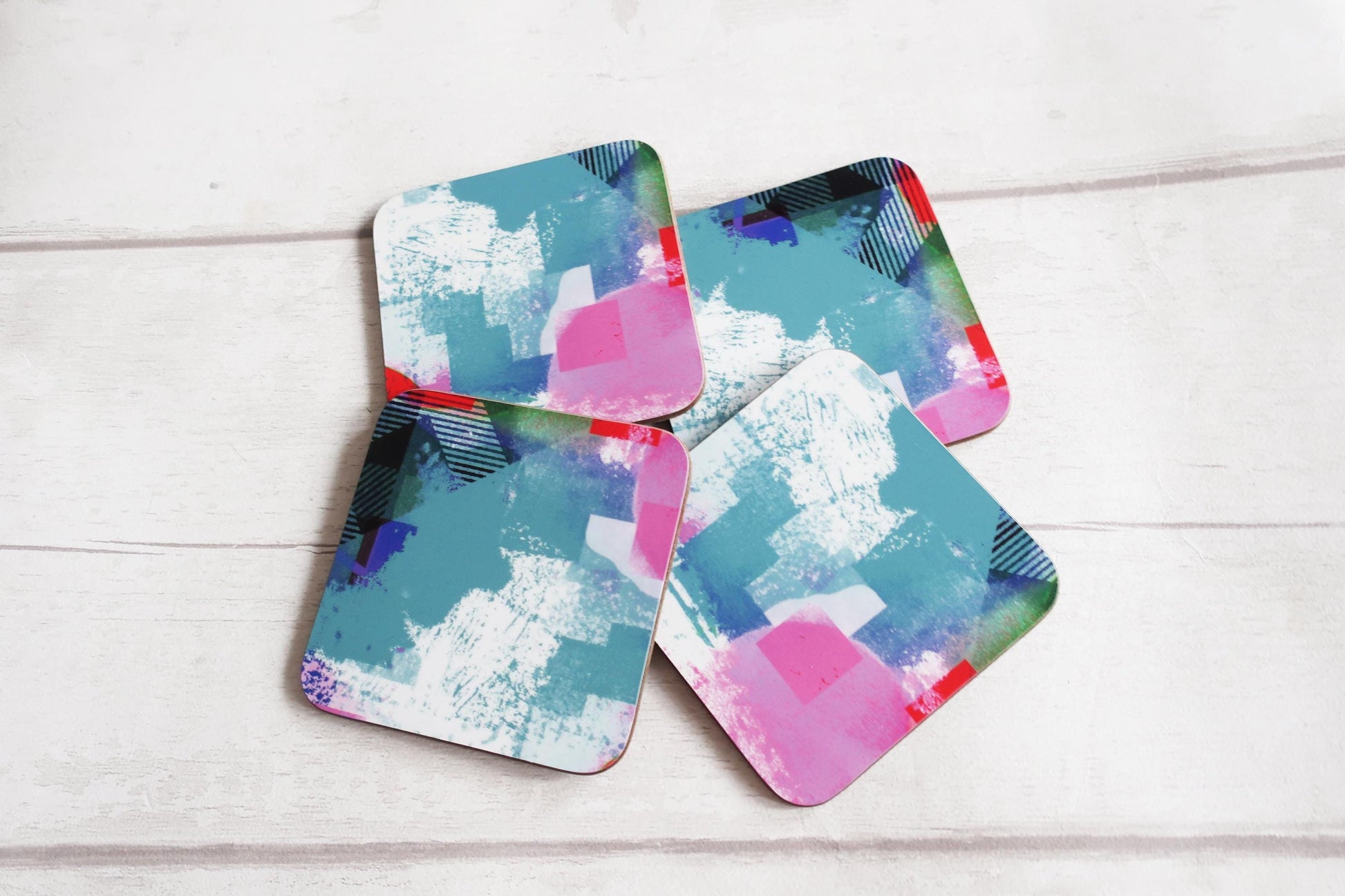Set of four colorful coasters on a light wooden surface