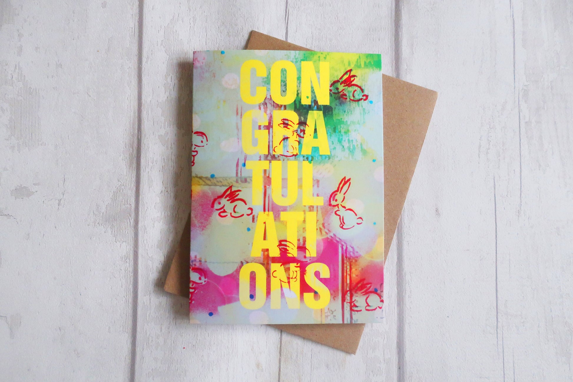 Colorful greeting card with 'Congratulations' text on a wooden surface