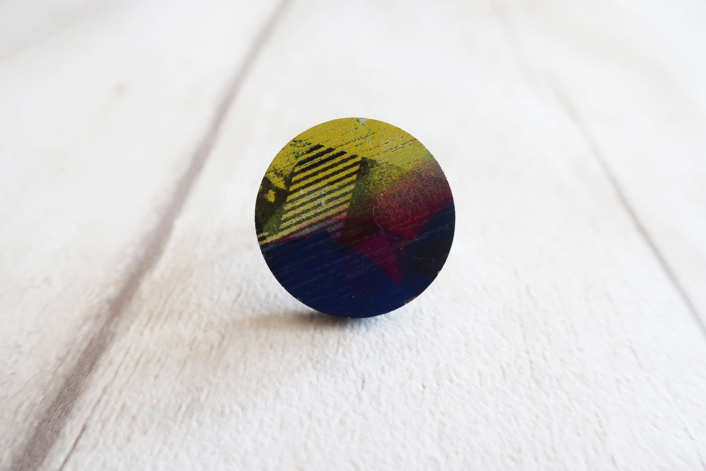Round multicolored ring on a white fabric background