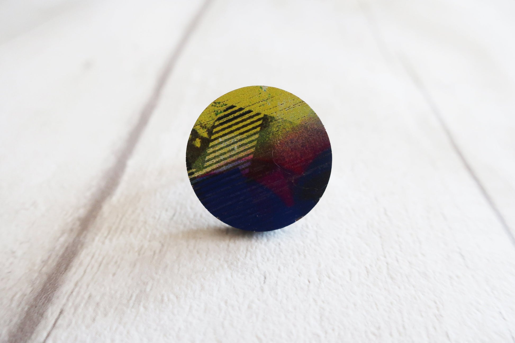 Round multicolored ring on a white fabric background