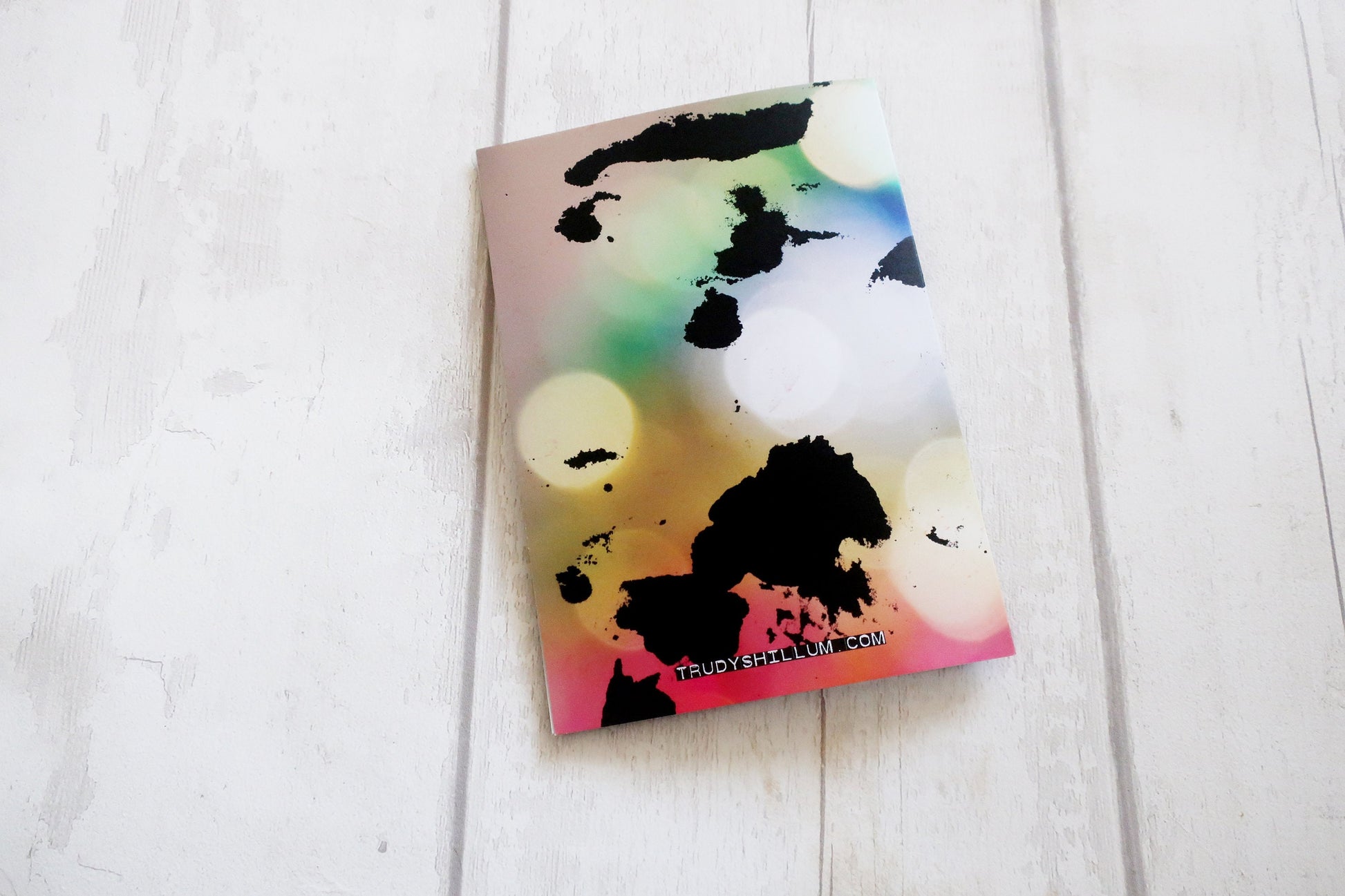 Colorful card with abstract design on a white wooden surface