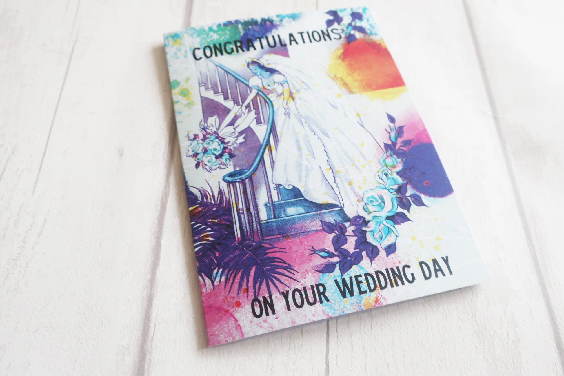 Colorful wedding card with tropical design on a white surface