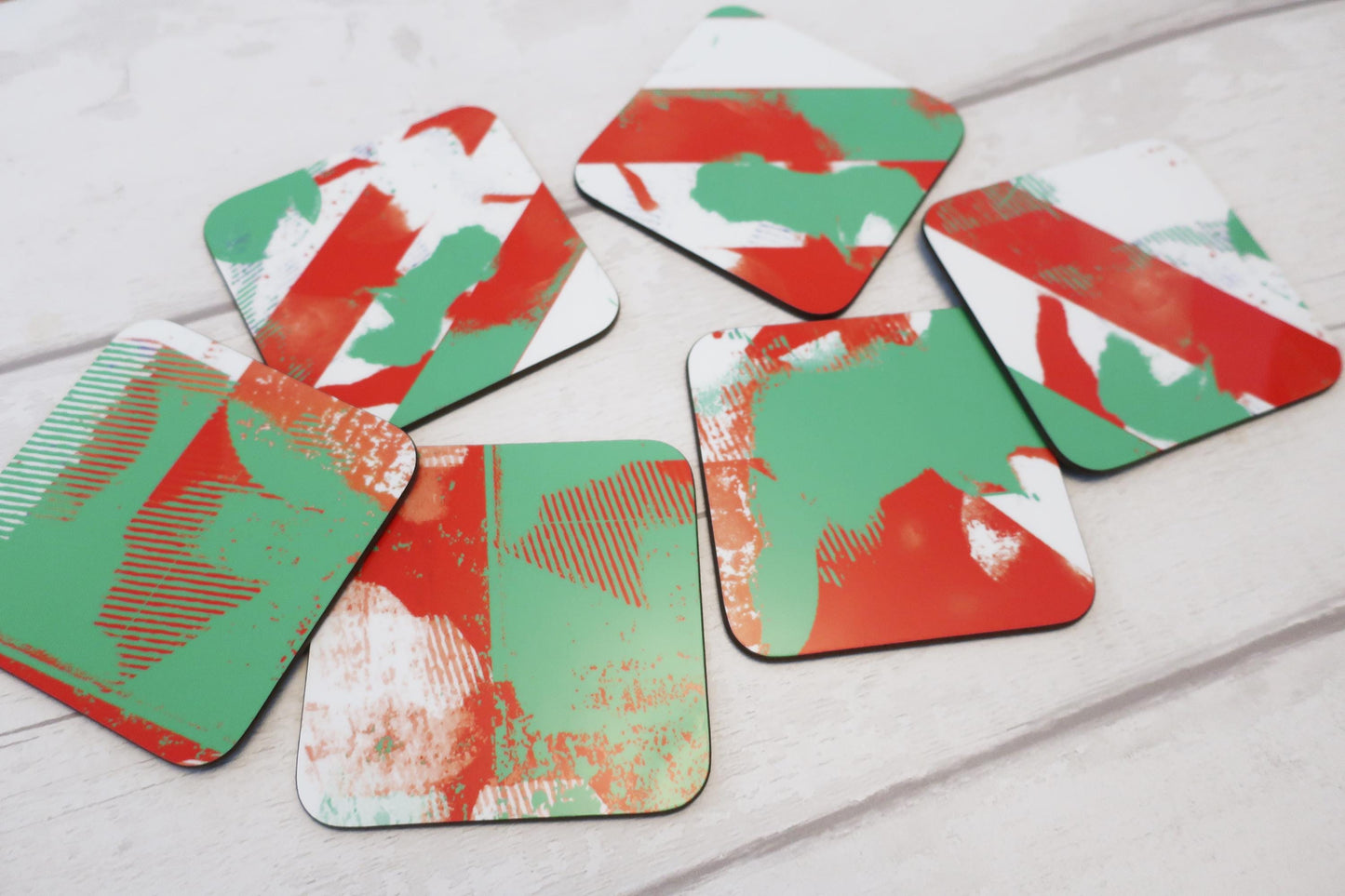 Set of red and green coasters on a light wooden surface
