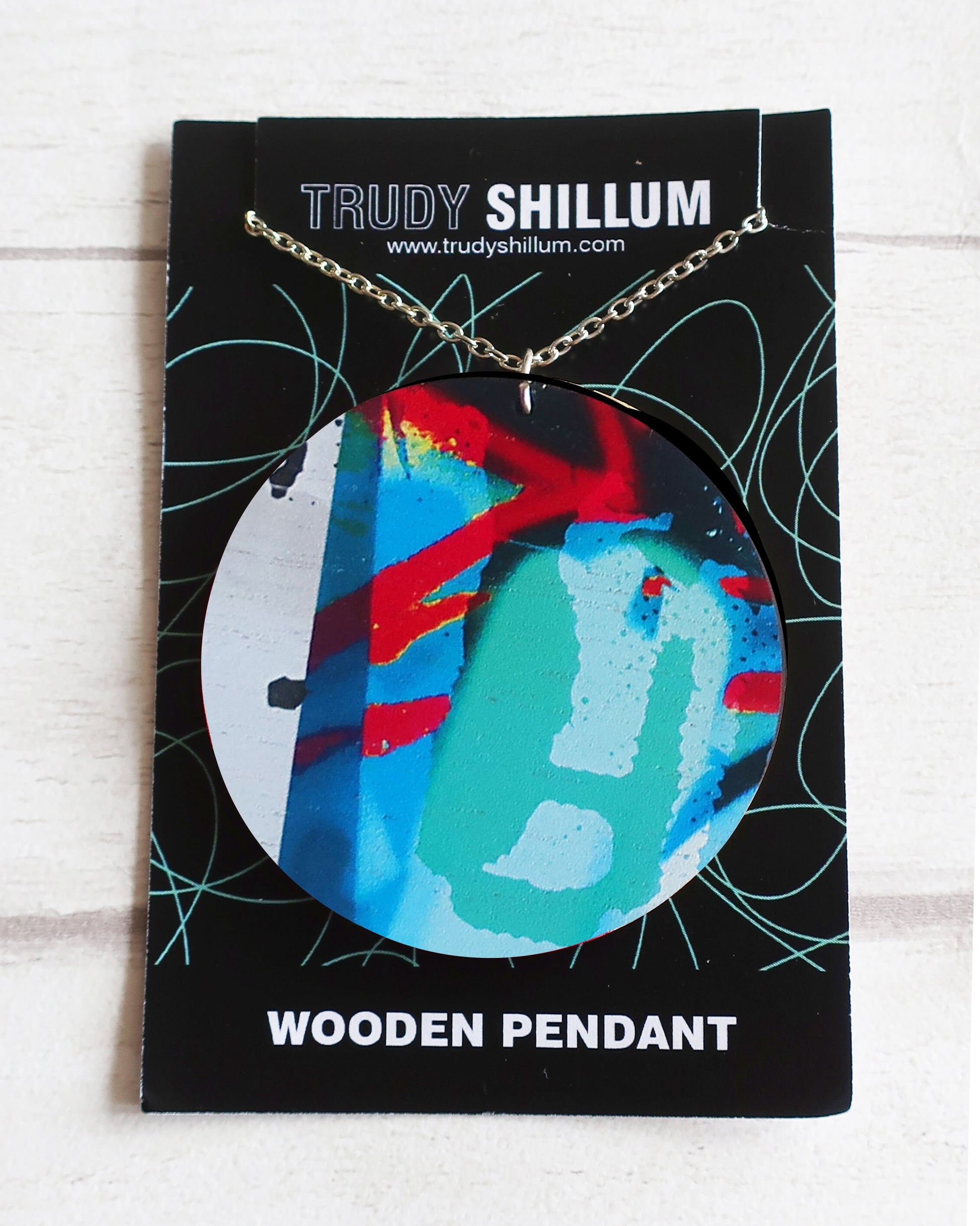 Wooden pendant on a Trudy Shillum branded card with a white background