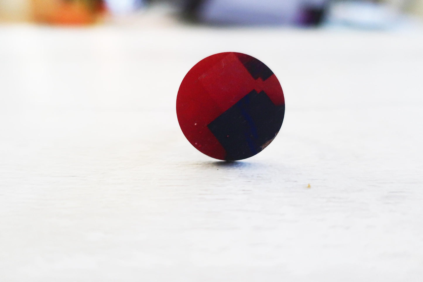Ring with red and blue design on a white surface