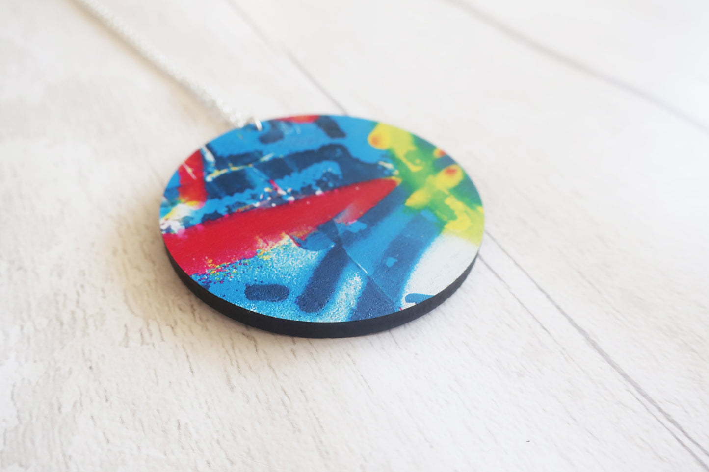 Colorful round pendant on a white surface