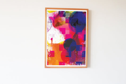 Framed abstract artwork with vibrant colors on a white wall