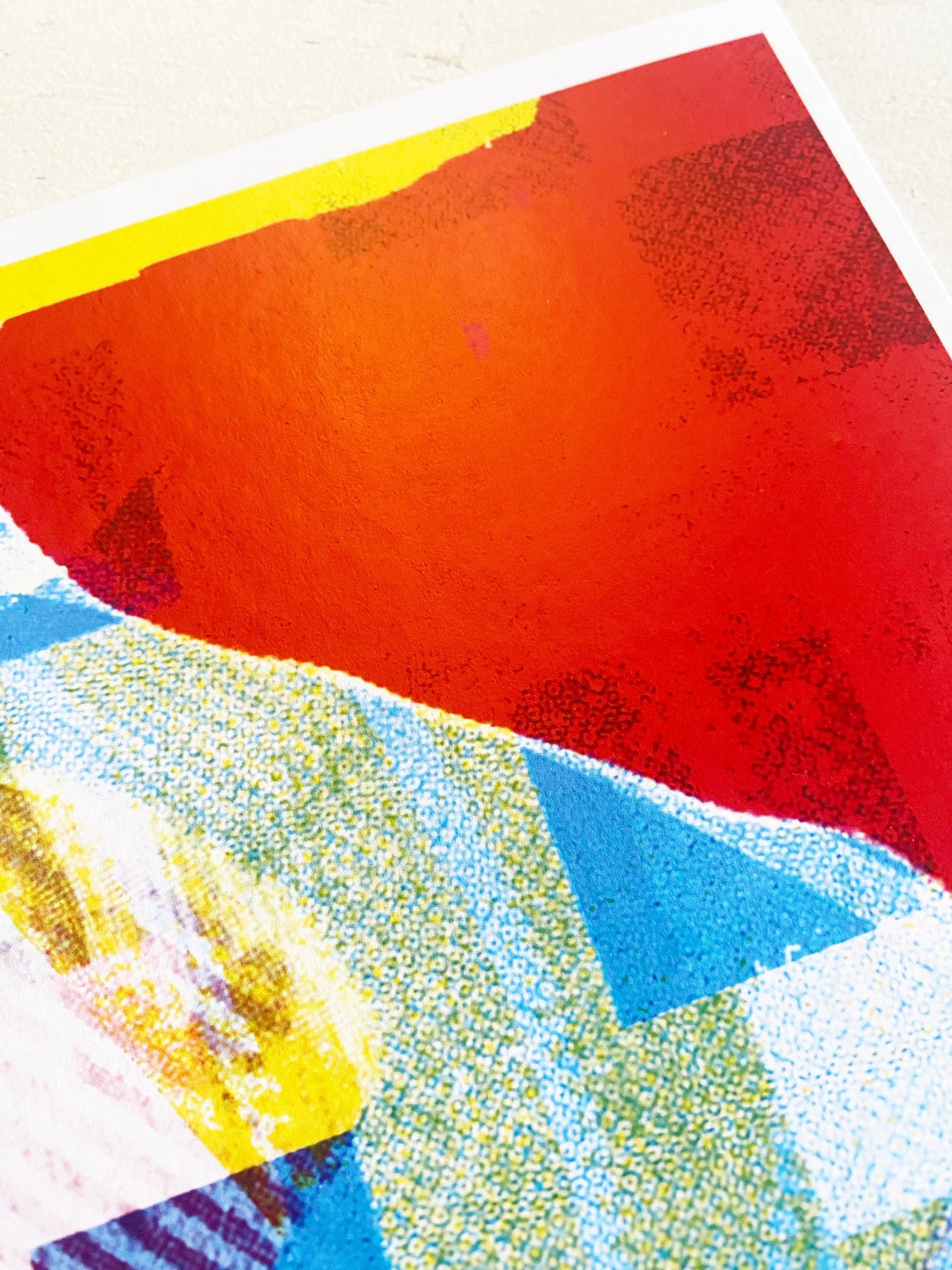 Abstract art piece with red, blue, and yellow colors on a textured surface.