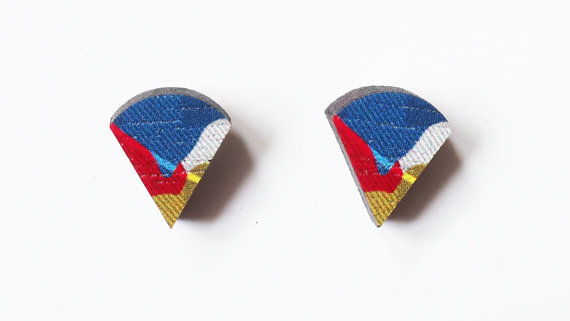 Pair of teardrop-shaped earrings with blue, red, and yellow design on a white background