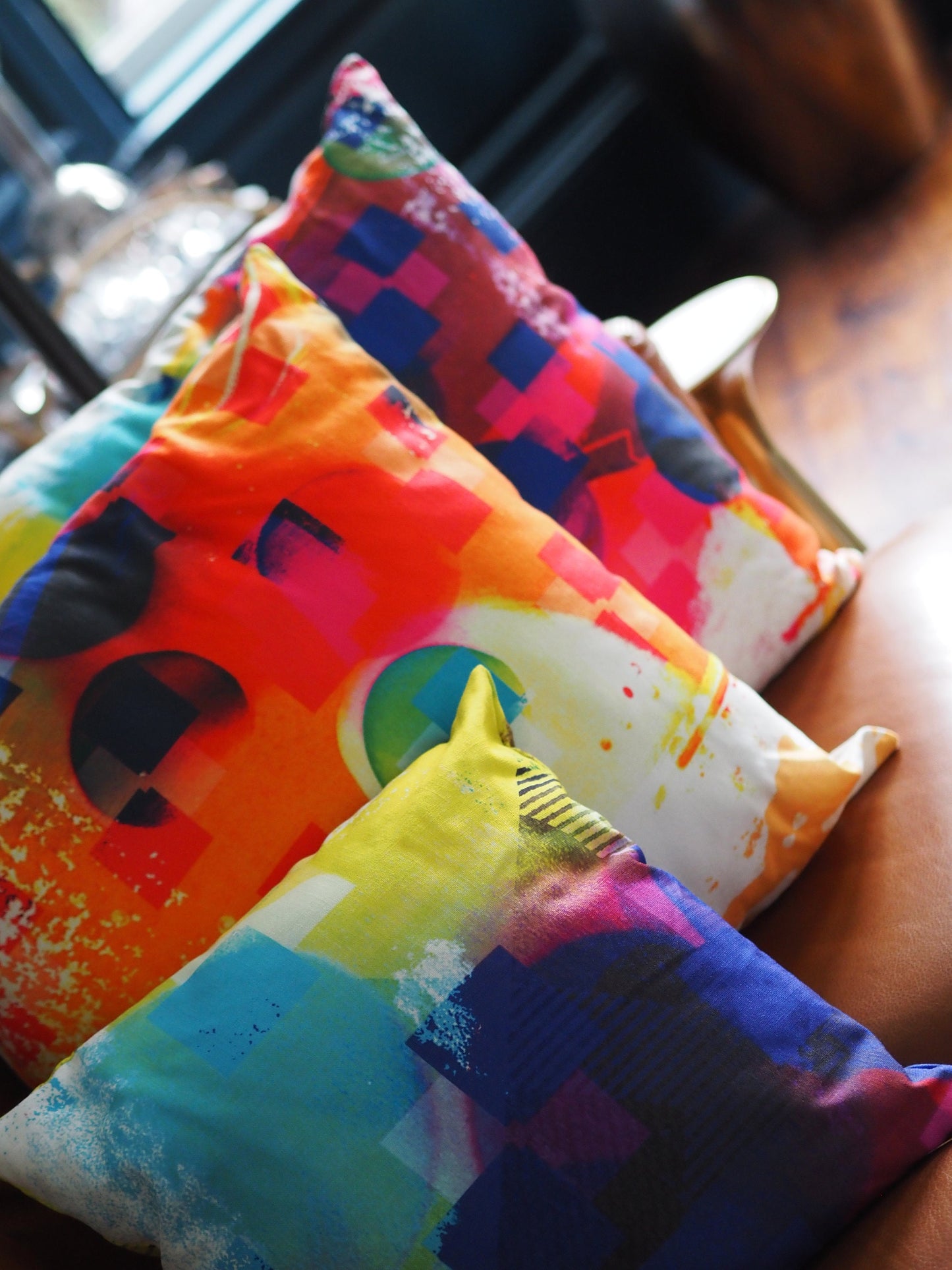 Colorful pillows with abstract patterns on a blurred indoor background