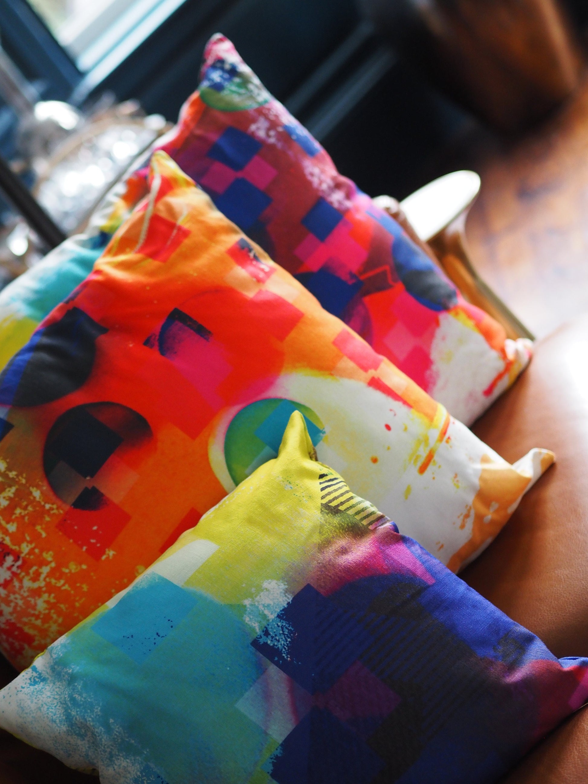 Colorful pillows with abstract patterns on a blurred indoor background